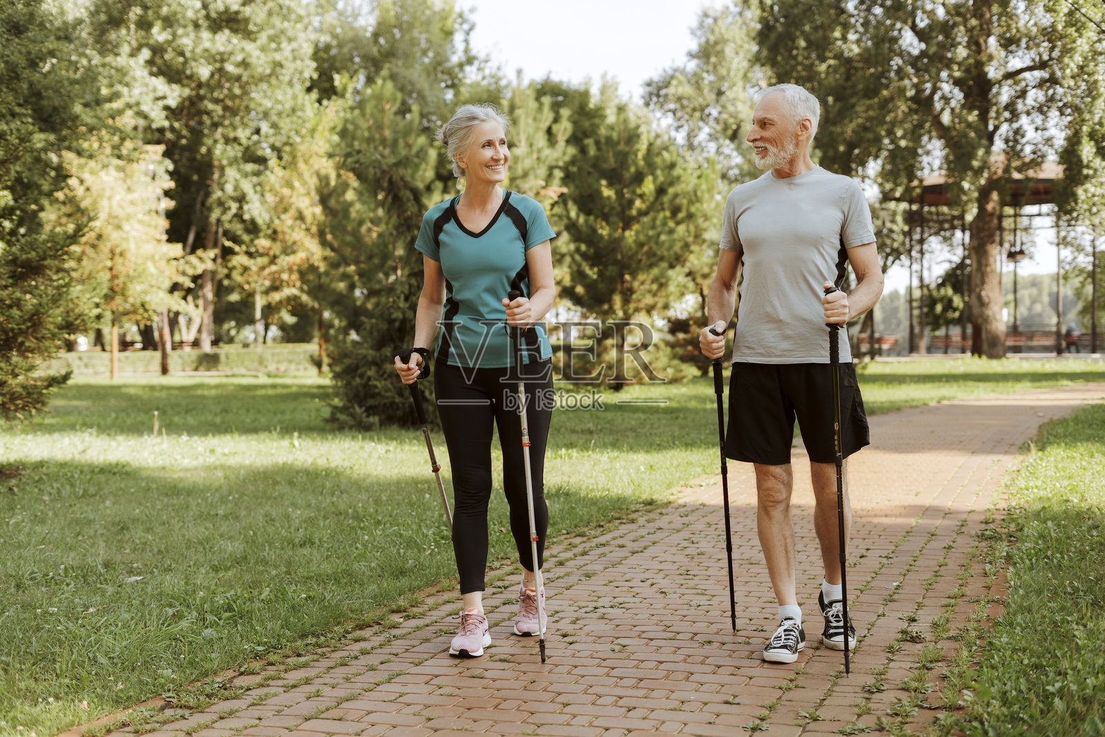 迷人的老年夫妇在公园里一起享受北欧健走锻炼照片摄影图片