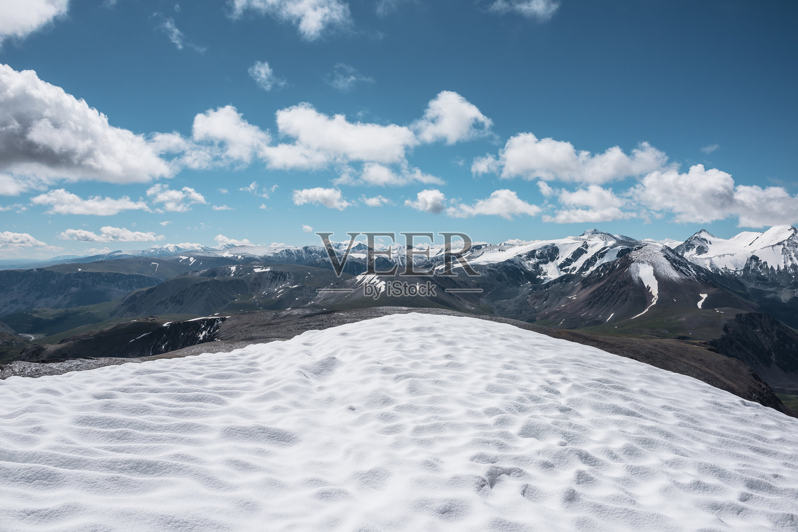 从雪顶的顶视图俯瞰广阔的阿尔卑斯山脉。高耸的山脉轮廓与雪白的山顶。阳光下的雪原。云层下的大型山脉,白雪皑皑的山峰。照片摄影图片