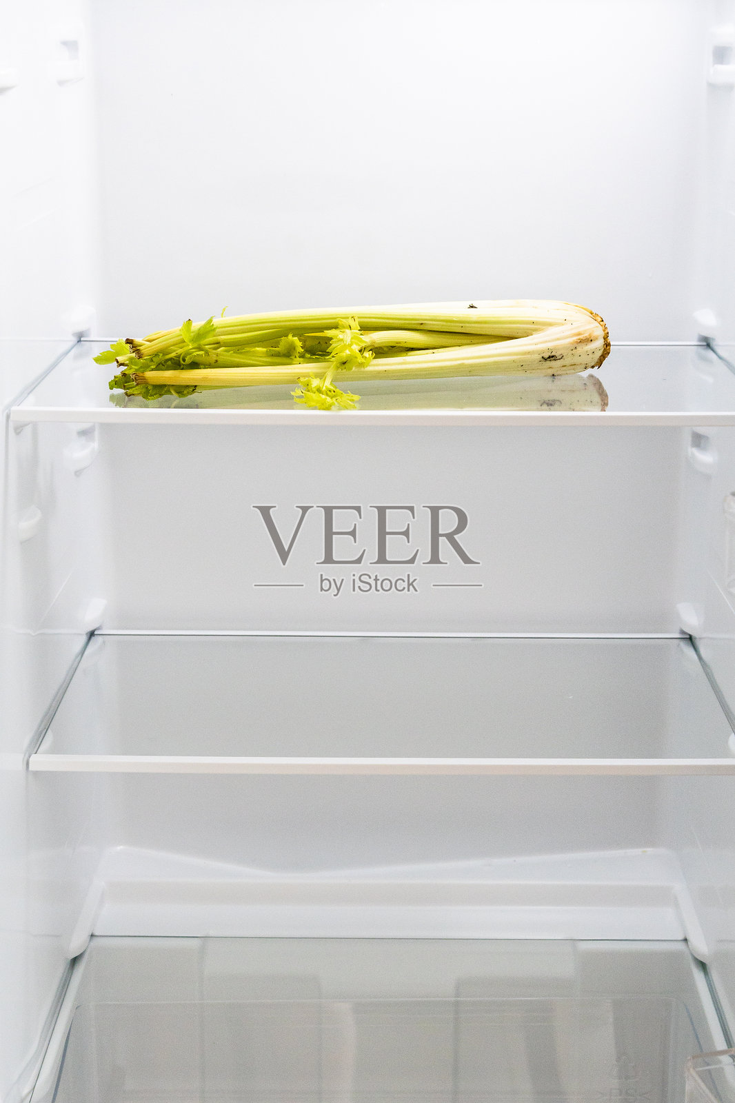厨房冰箱架子上放着枯萎的芹菜照片摄影图片