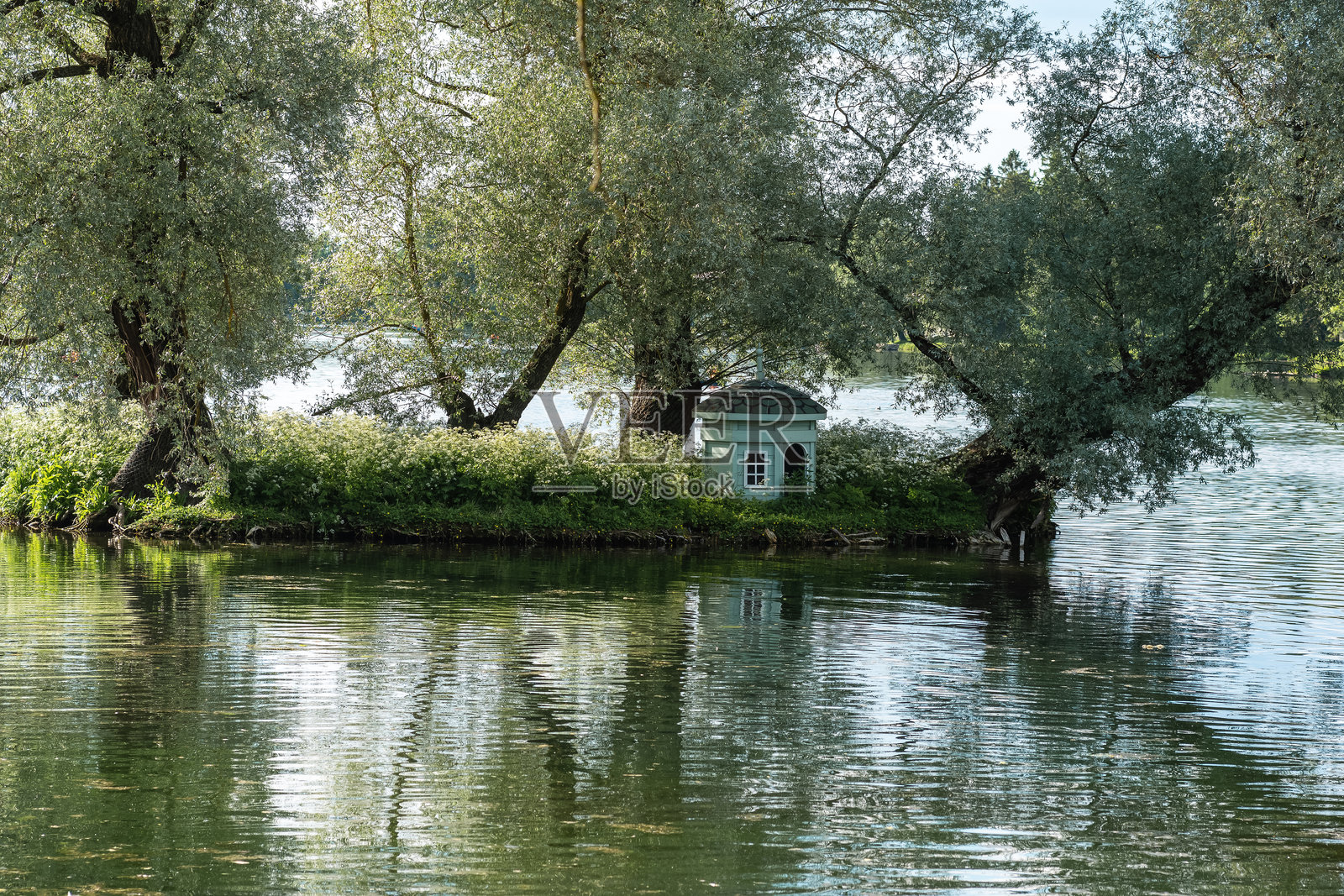 公园风景,池塘中的小岛上有一个供水鸟栖息的房子照片摄影图片