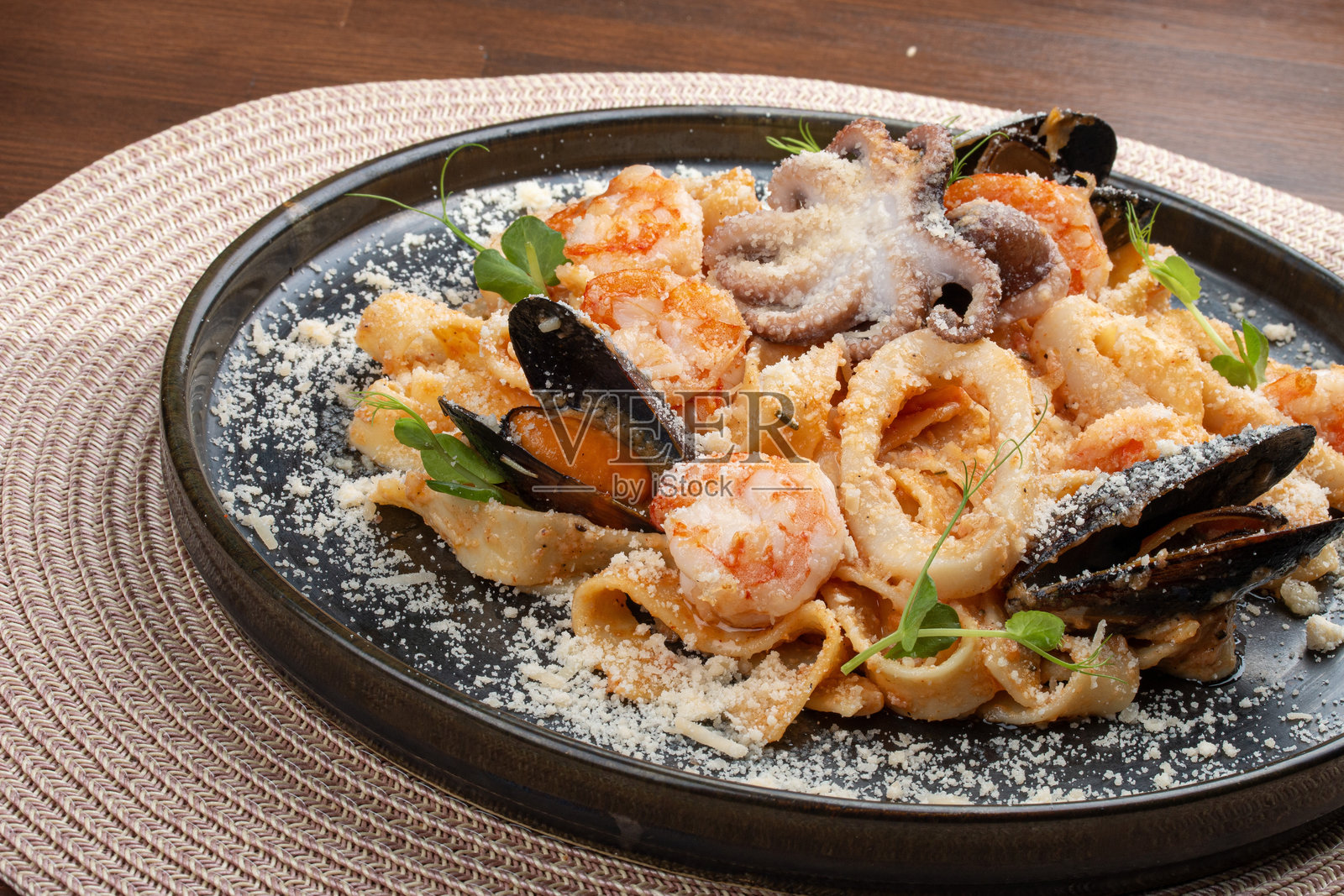 海鲜意大利宽面条配番茄奶油酱。这道意大利风味的菜肴提供了来自海洋的丰富口感和风味的美妙结合。照片摄影图片