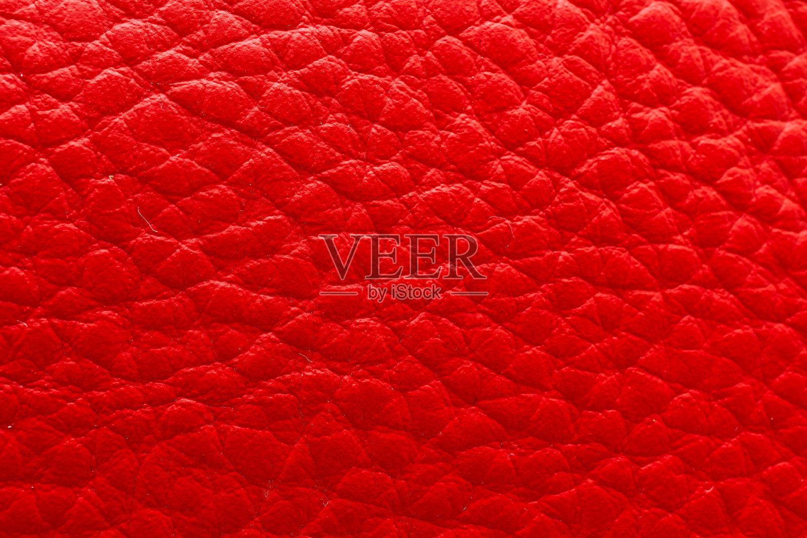 特写红色皮革,展示其鲜艳的色调和复杂的表面细节,非常适合时尚或设计项目。照片摄影图片