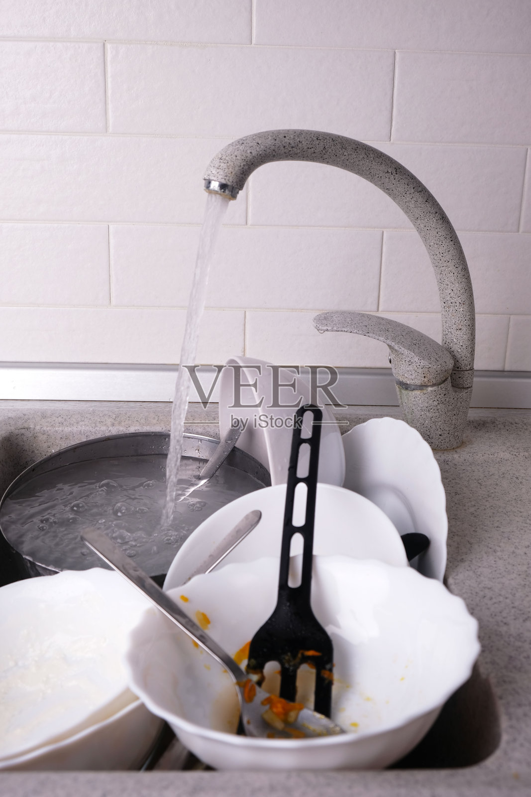 厨房水槽里堆满了脏碗碟和餐具,特写镜头照片摄影图片