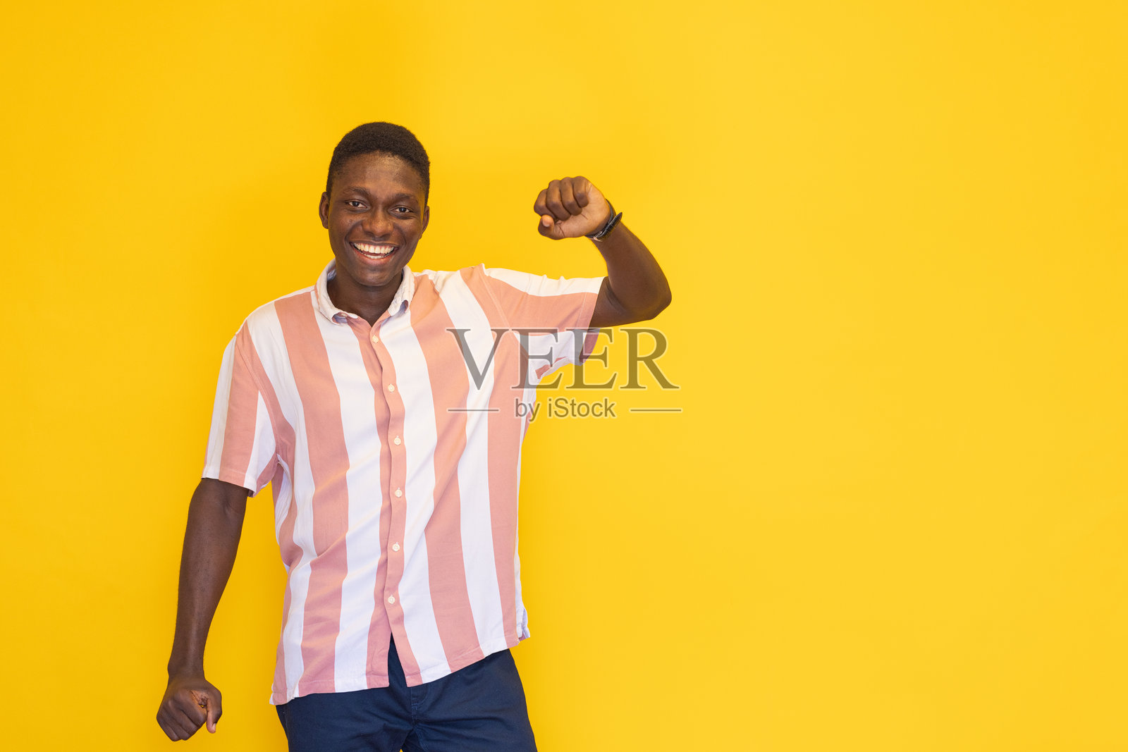 微笑的年轻人站在黄色背景前照片摄影图片