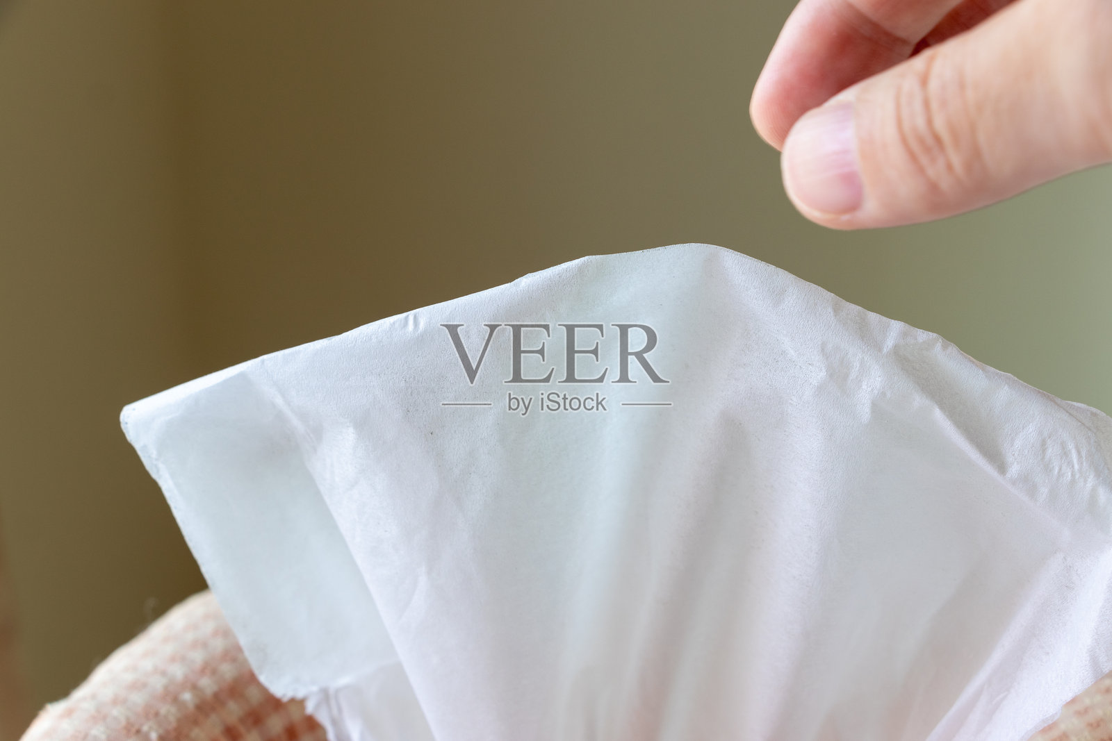 用手指捏住纸巾,从盒子里抽出来照片摄影图片