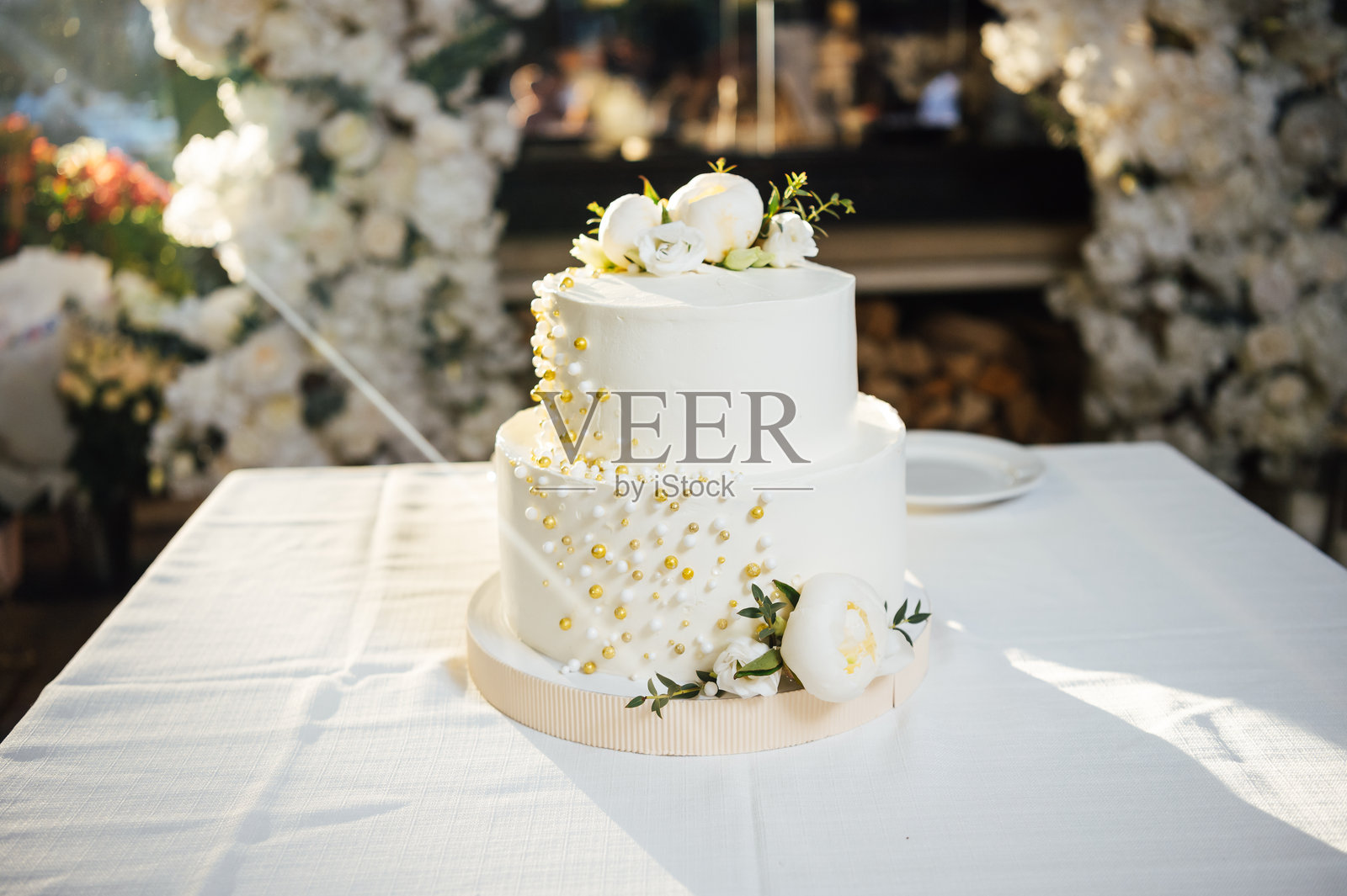 一款美丽的婚礼蛋糕在阳光下的桌子上。照片摄影图片