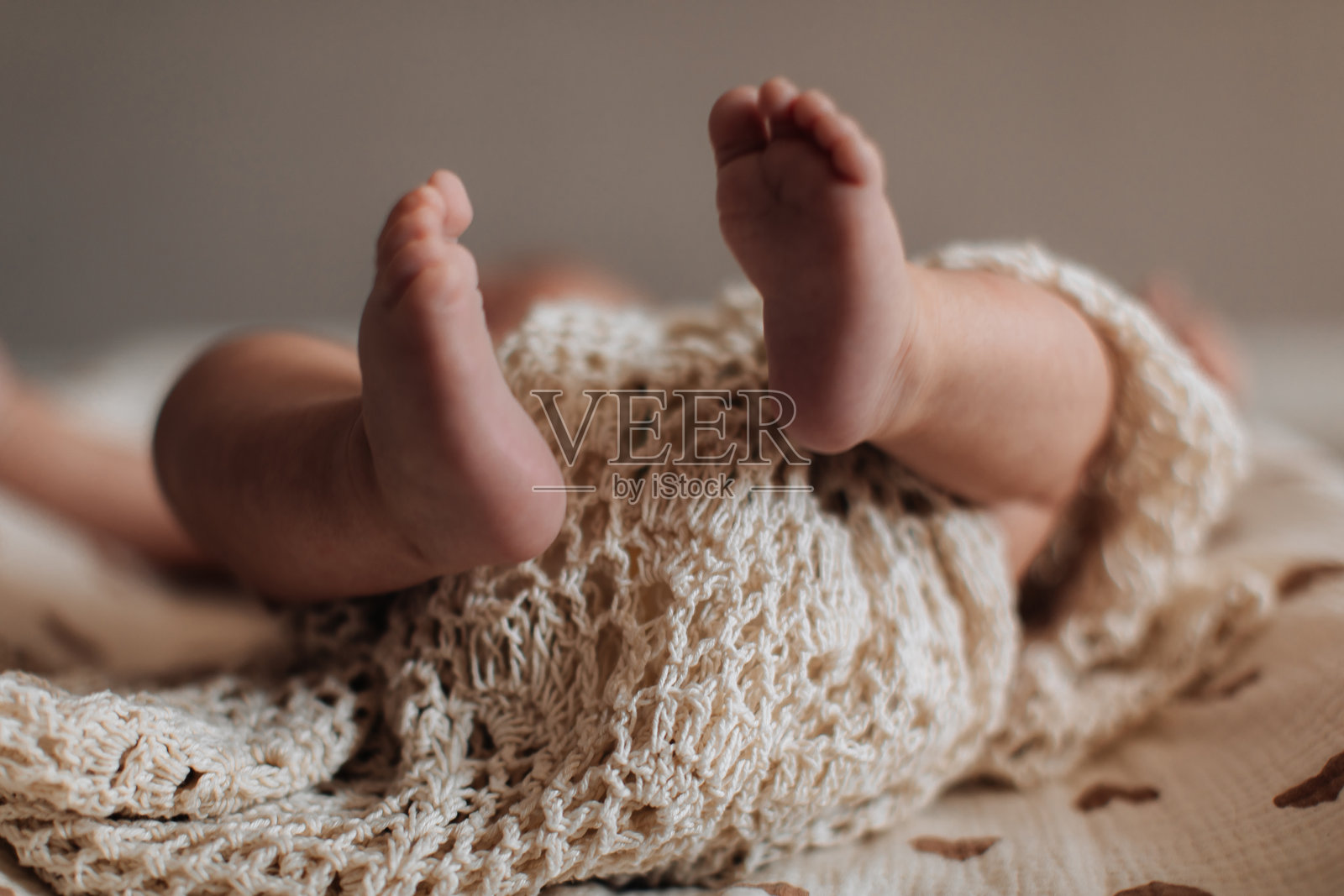 新生儿的小脚丫在米色背景上,婴儿护理和父母亲情的概念照片摄影图片