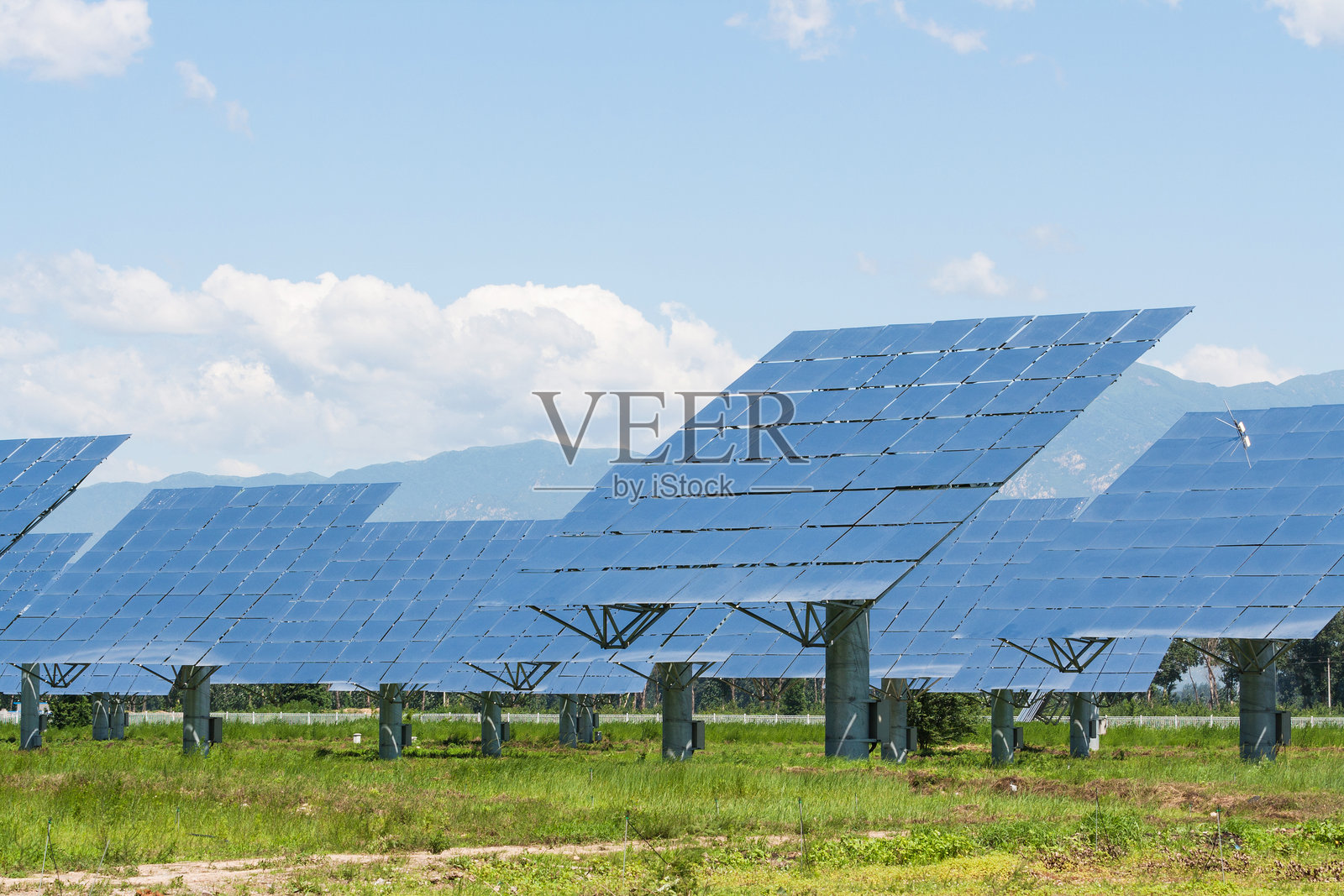 草地上光伏太阳能发电站照片摄影图片