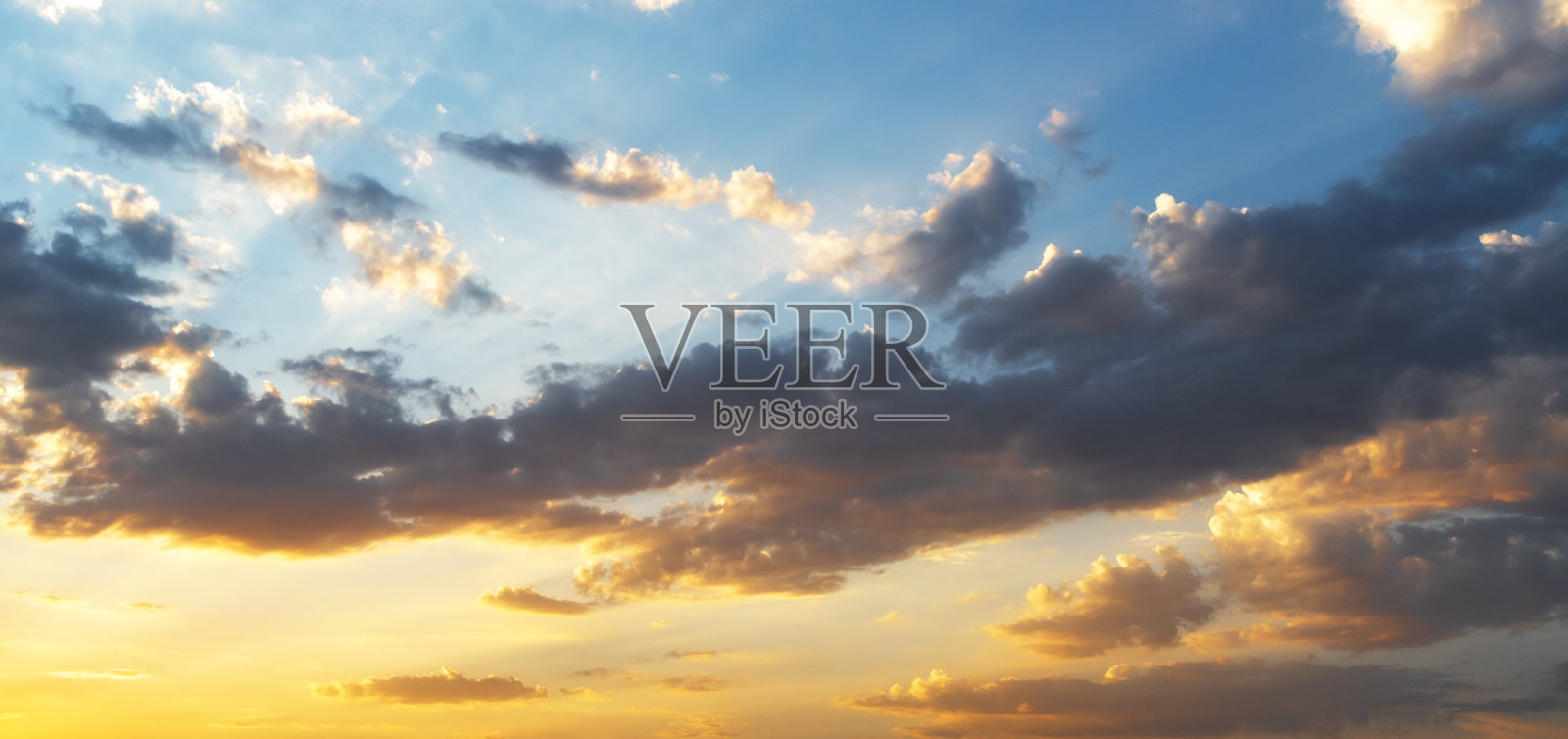 明亮的橙色日落天空与戏剧性的云彩。天空背景。照片摄影图片