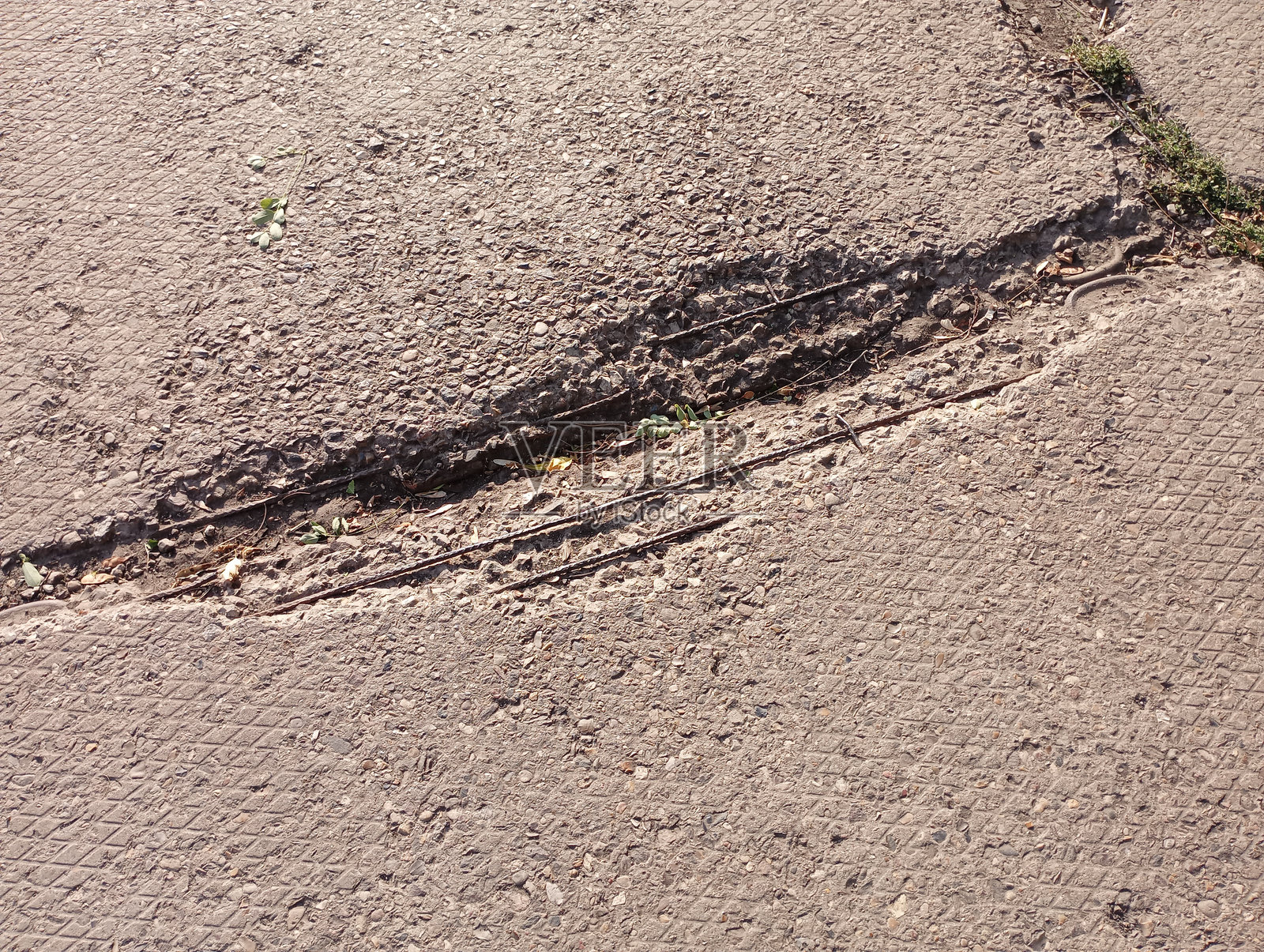 受损的混凝土路面,露出混凝土板框架加固。照片摄影图片