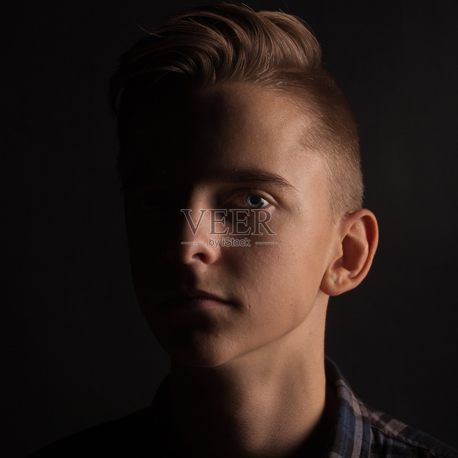 年轻男子的特写肖像,背景为黑色照片摄影图片