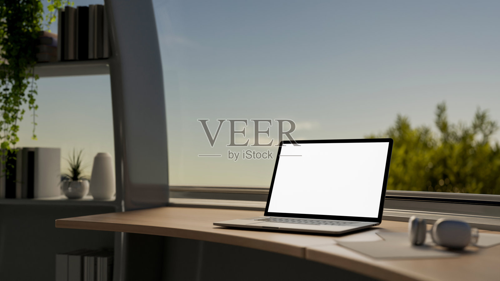 现代房间桌子上的笔记本电脑模型,靠在大窗户旁,窗外可以看到天空。照片摄影图片