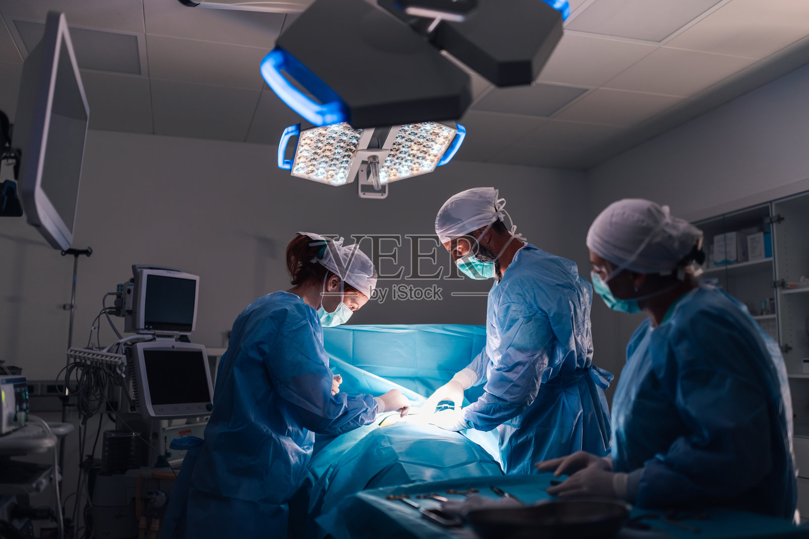 外科团队在手术室明亮的灯光下努力工作照片摄影图片