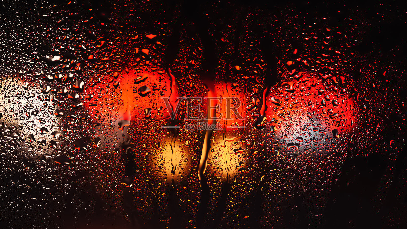 窗户上的雨滴。玻璃上的水珠。抽象背景。多彩的斑点。水滴的纹理。照片摄影图片