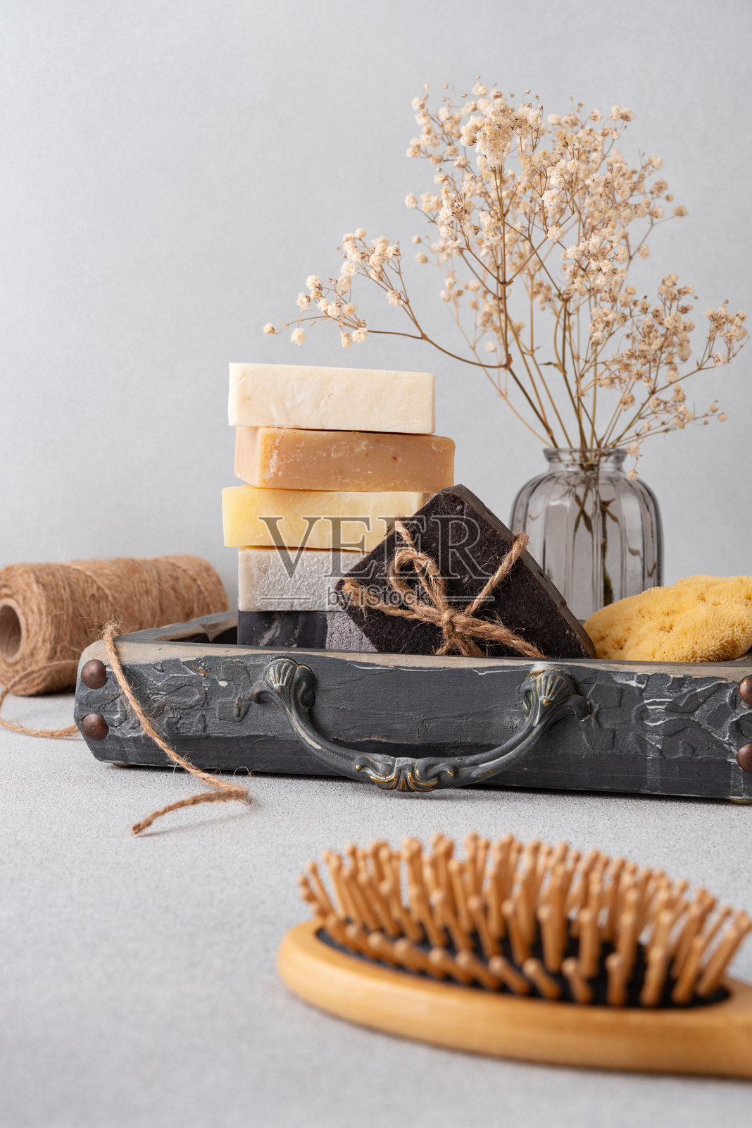 精美布置的浴室用品套装,包含手工香皂、木质发刷和天然海绵照片摄影图片