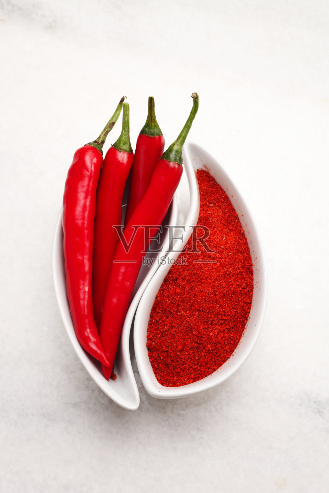 白色桌子上的红辣椒和辣椒粉照片摄影图片
