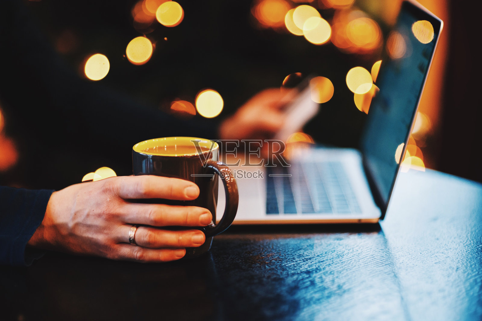 男人在桌子上拿着咖啡,靠近笔记本电脑的特写镜头照片摄影图片