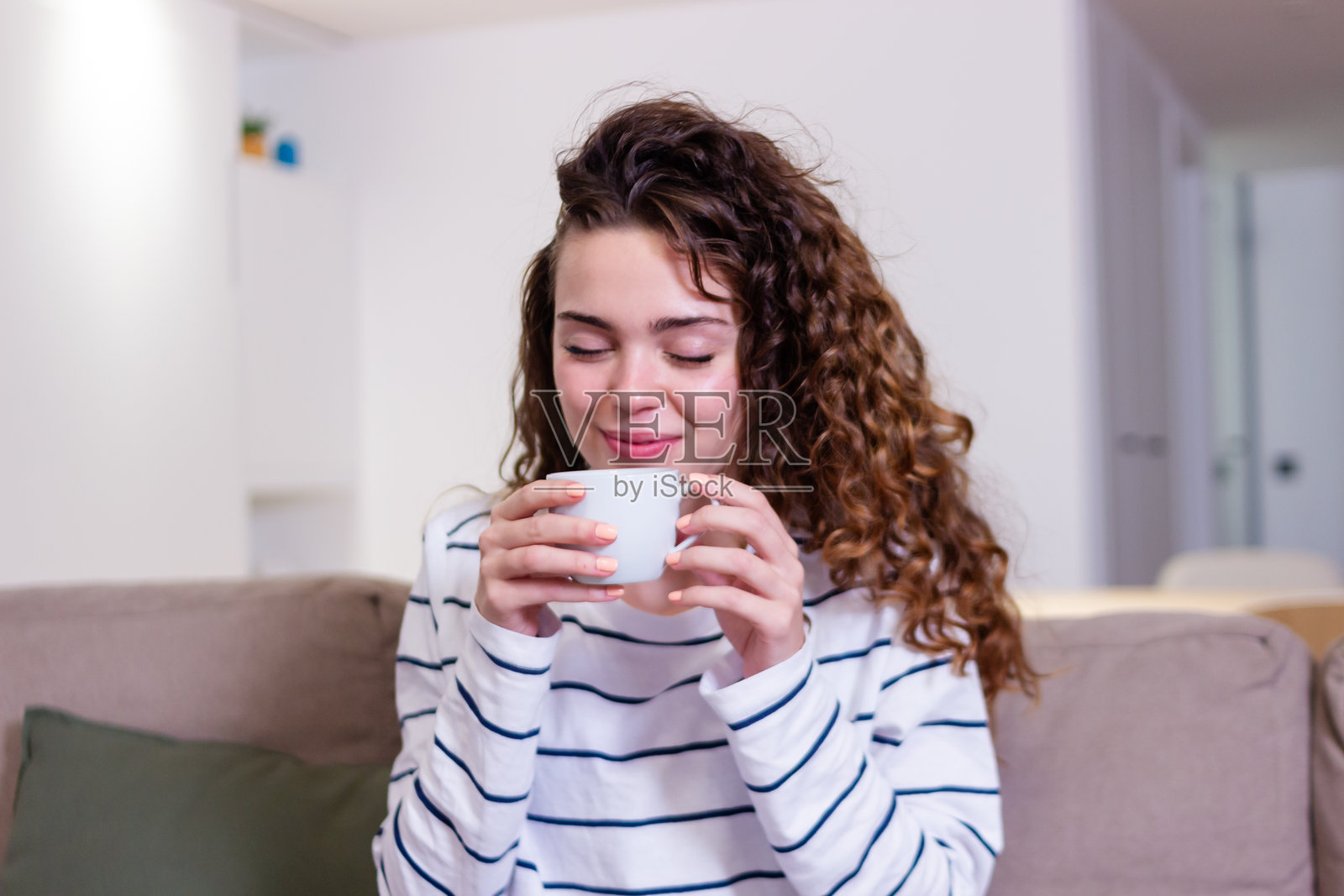 美丽的年轻女性在家中享受一杯咖啡照片摄影图片