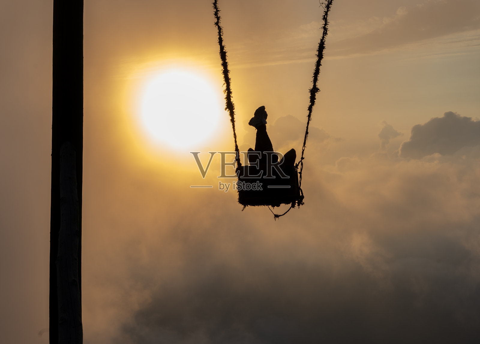 女人在云端荡秋千照片摄影图片