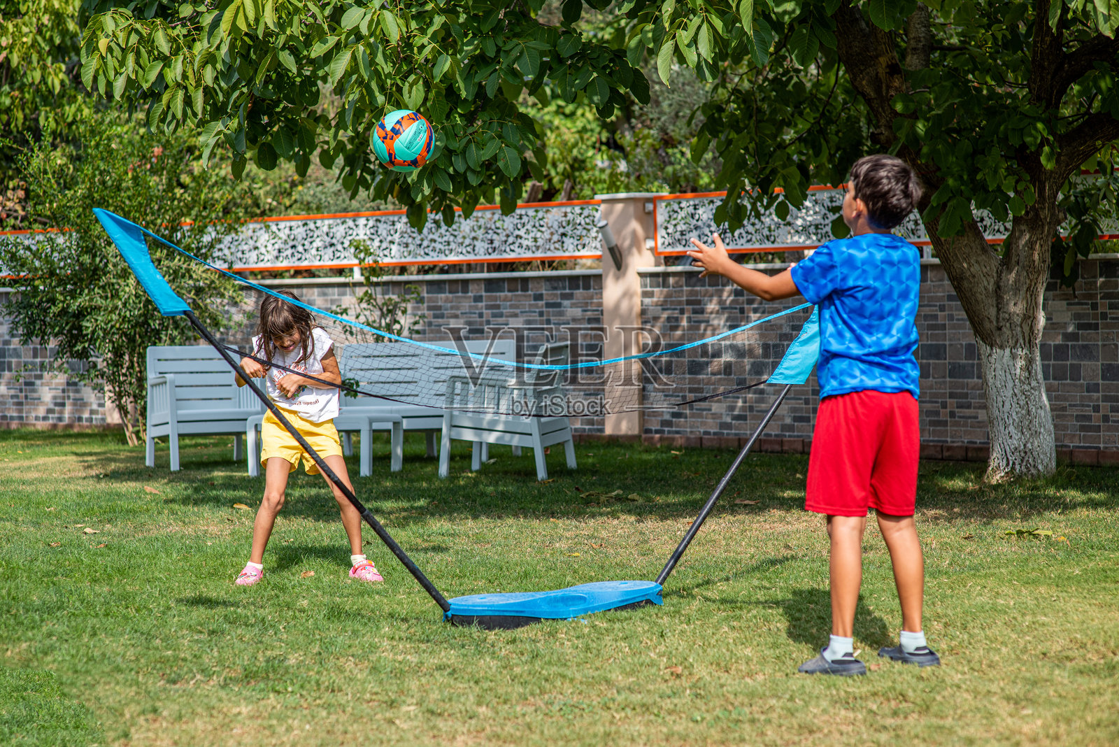 兄妹在后院打排球照片摄影图片