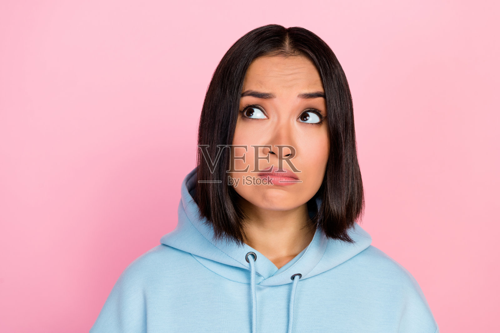 不高兴的女士看空白区域广告,粉色背景照片摄影图片