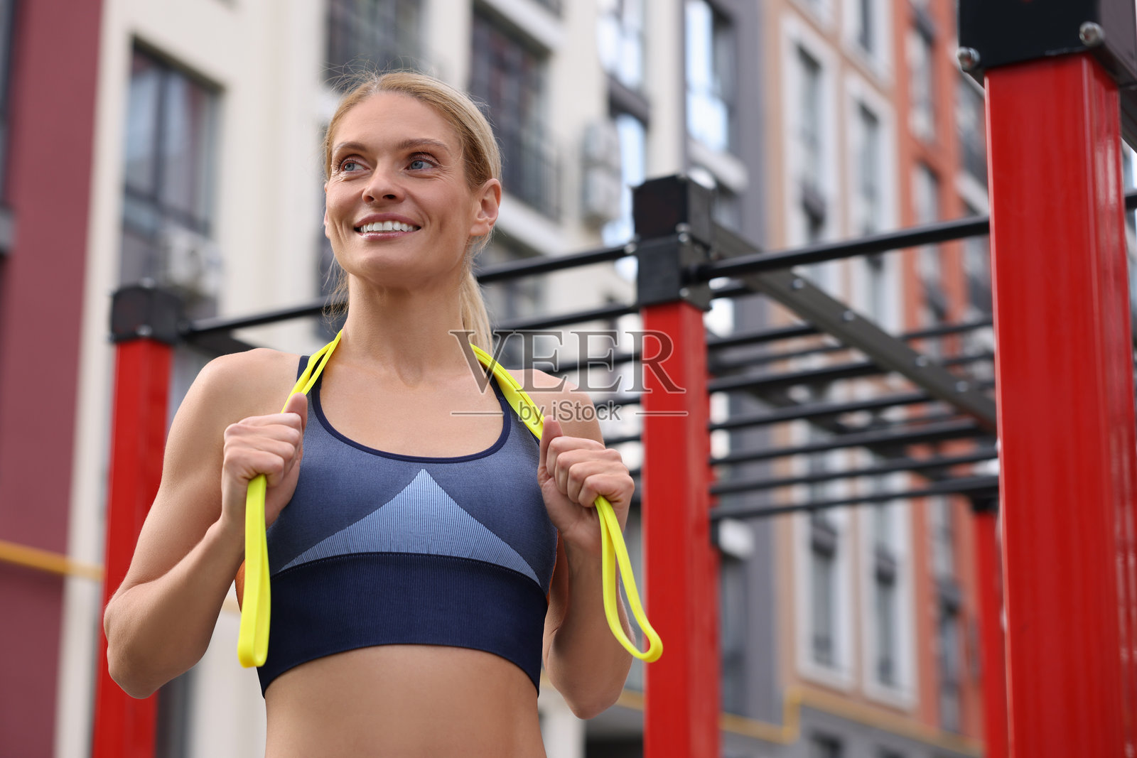 在户外健身房使用健身弹力带的运动型女人照片摄影图片