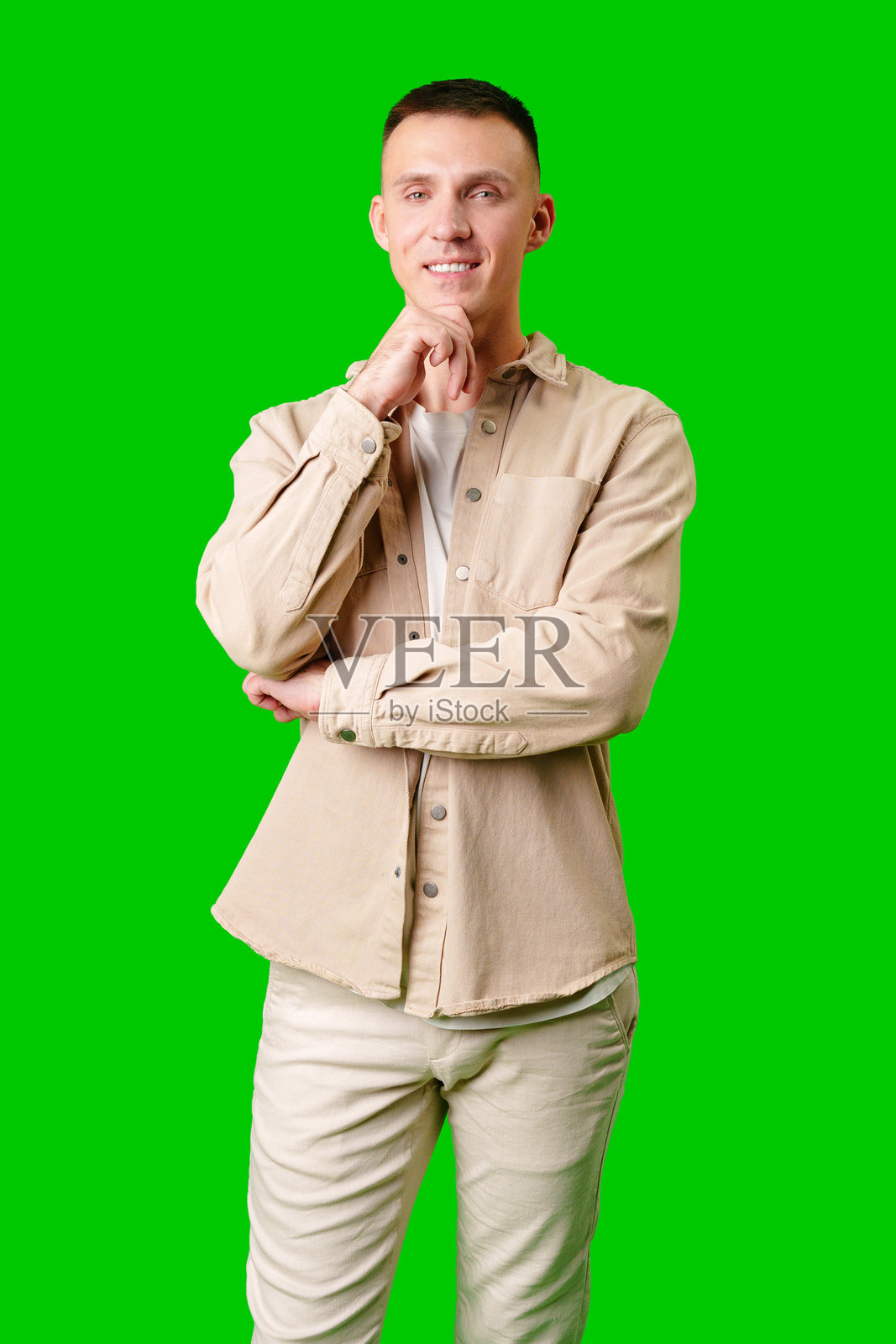 身着休闲装,在亮绿色背景下沉思的年轻男子照片摄影图片