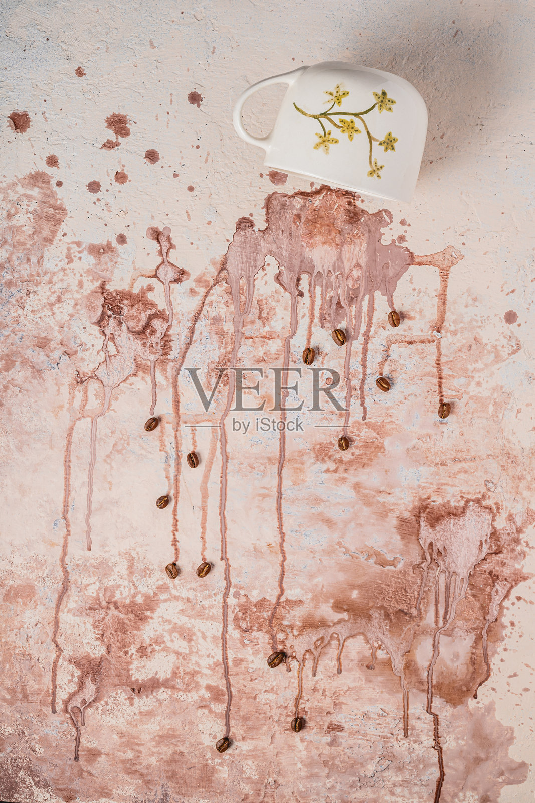 倒置的陶瓷杯。棕色液体飞溅。咖啡豆散落。照片摄影图片