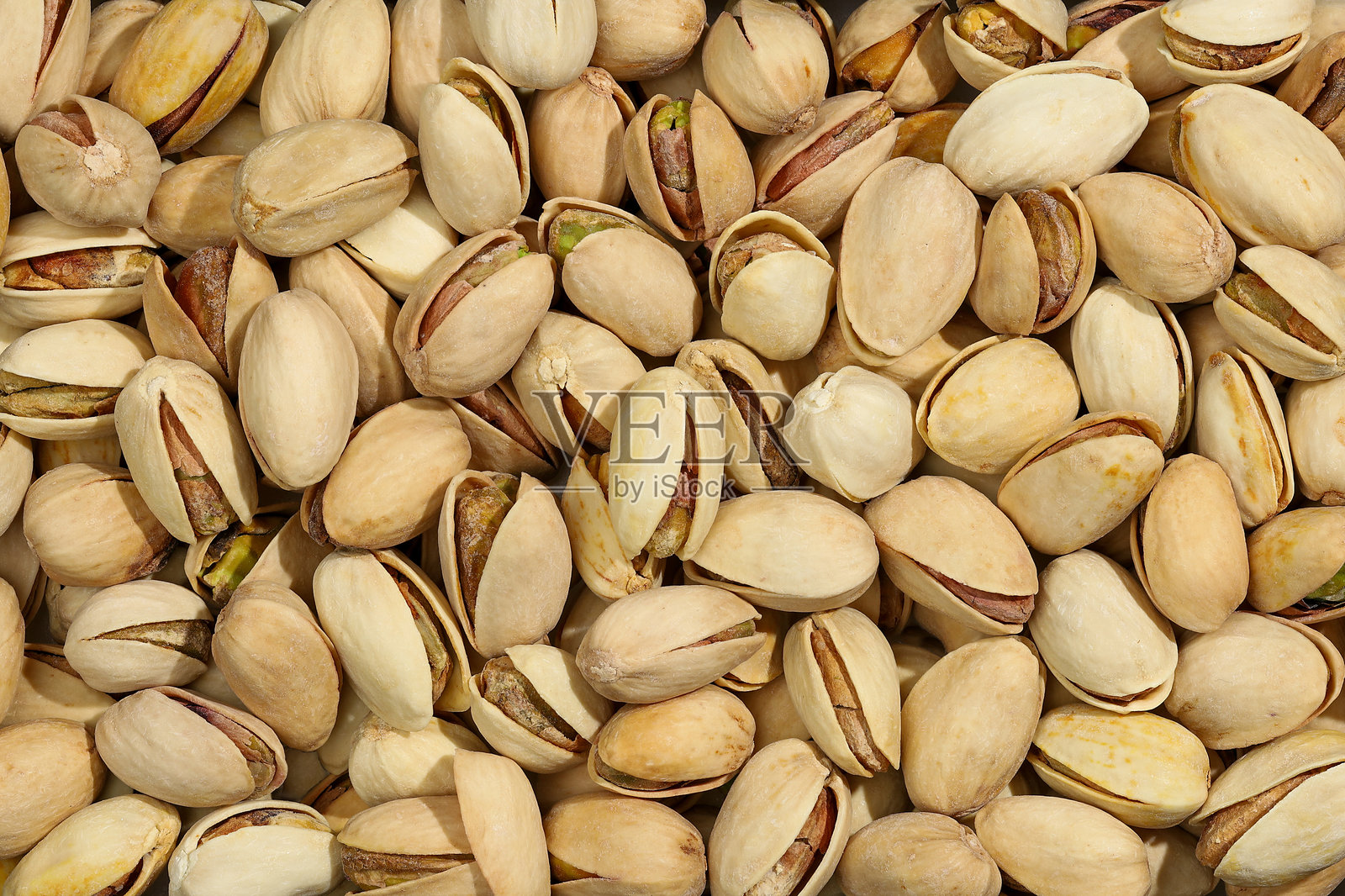 开心果营养价值高,含有超过50%的脂肪,以及大量的蛋白质和碳水化合物。它们具有滋补作用,推荐用于慢性疲劳。背景。照片摄影图片