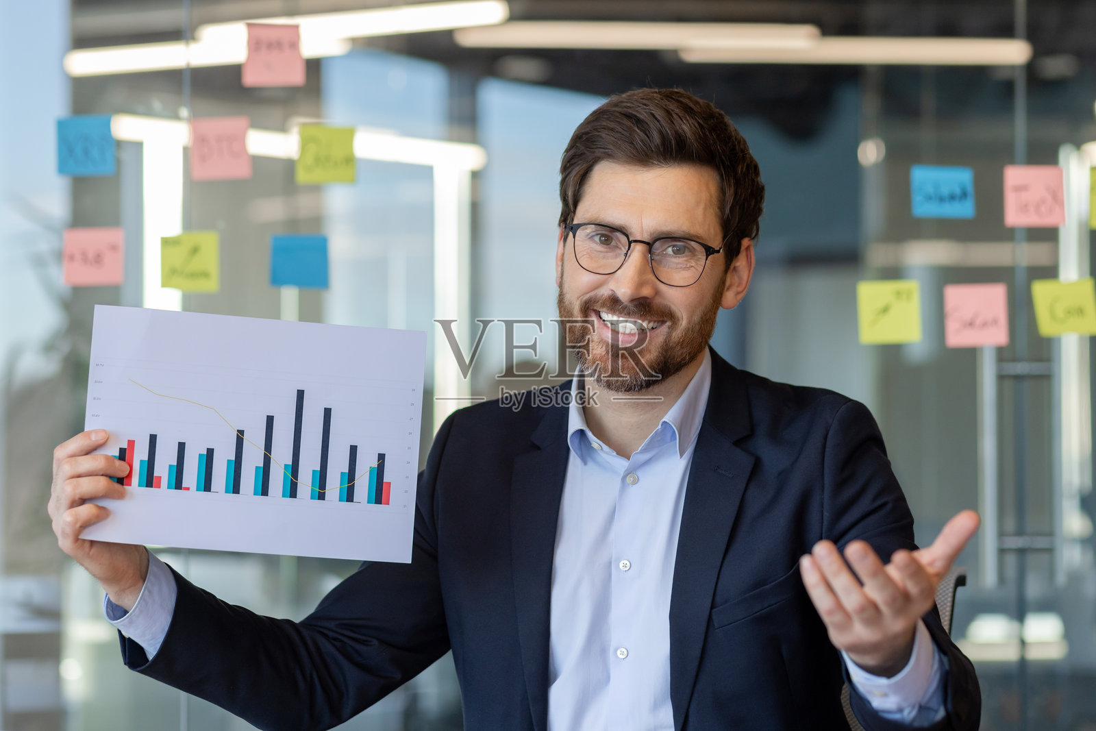充满活力的现代办公室中,自信的商人用彩色条形图展示数据分析照片摄影图片
