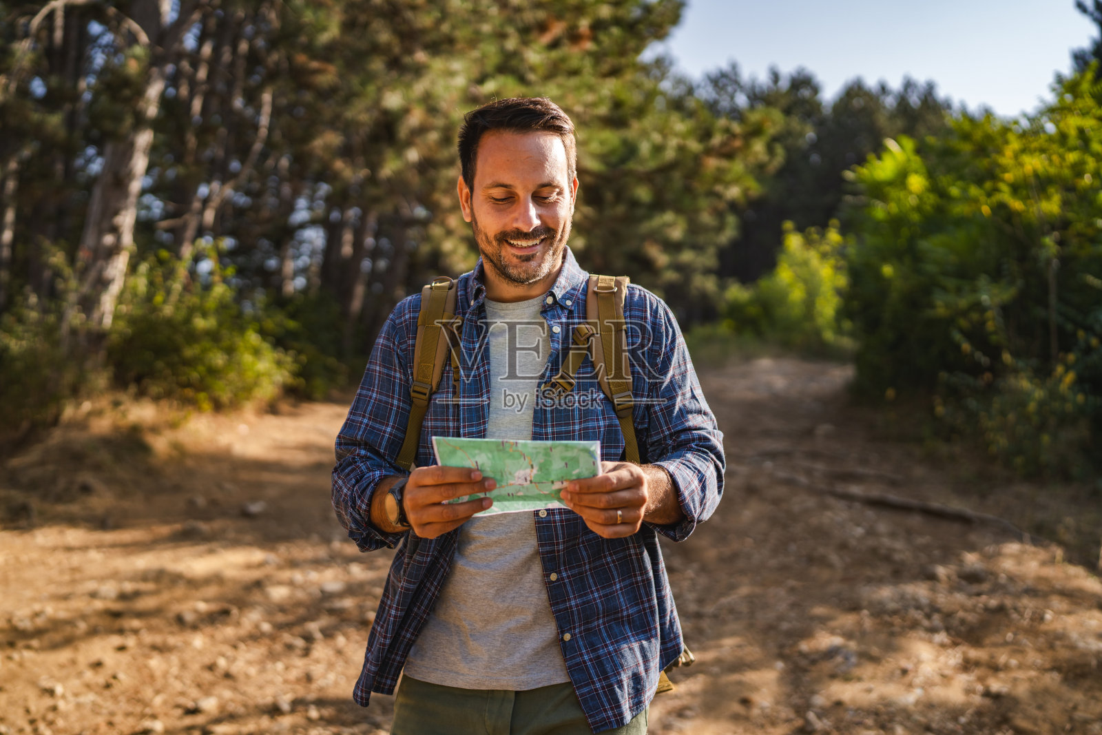 成年男性徒步旅行者站着使用地图寻找正确的方向照片摄影图片