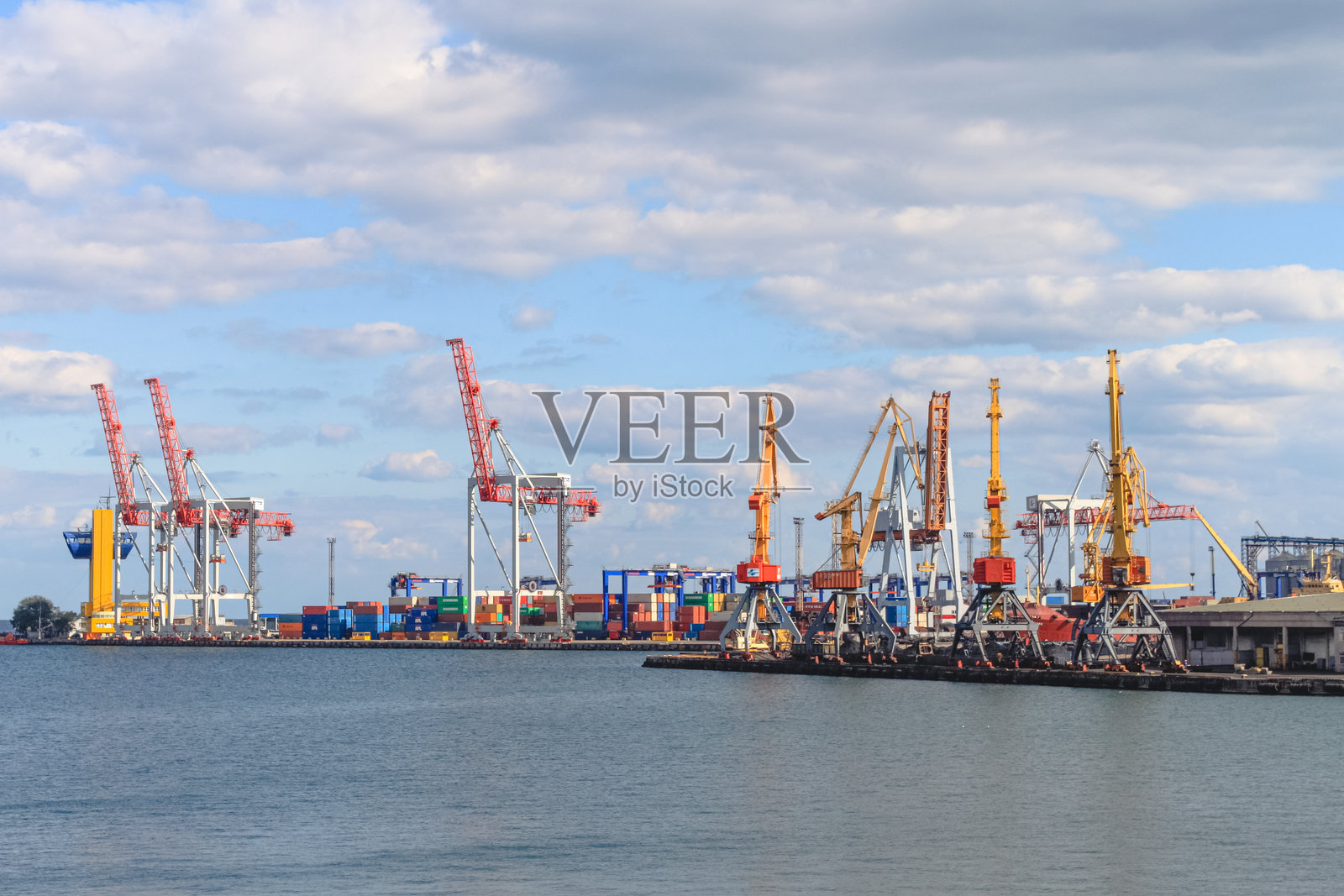 乌黑的天空下,黄色的海鸥在海港飞翔。敖德萨商业海港照片摄影图片