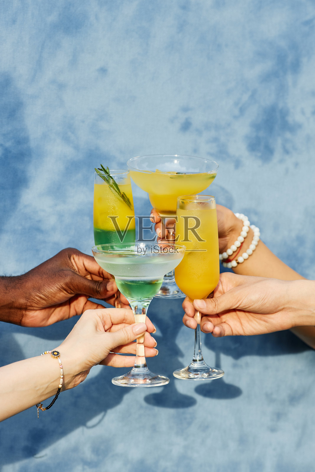 在蓝色背景下用色彩缤纷的鸡尾酒庆祝照片摄影图片