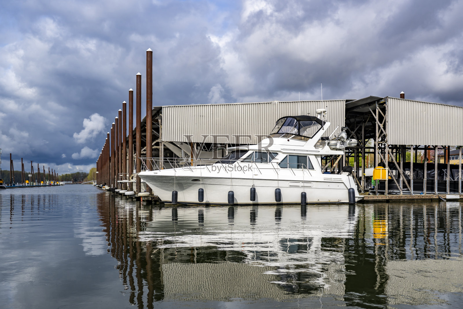 游艇和休闲船停靠在一个安静的水湾中的浮动码头上,码头设有遮蔽的停车位,等待着下一次的活跃休闲之旅。照片摄影图片