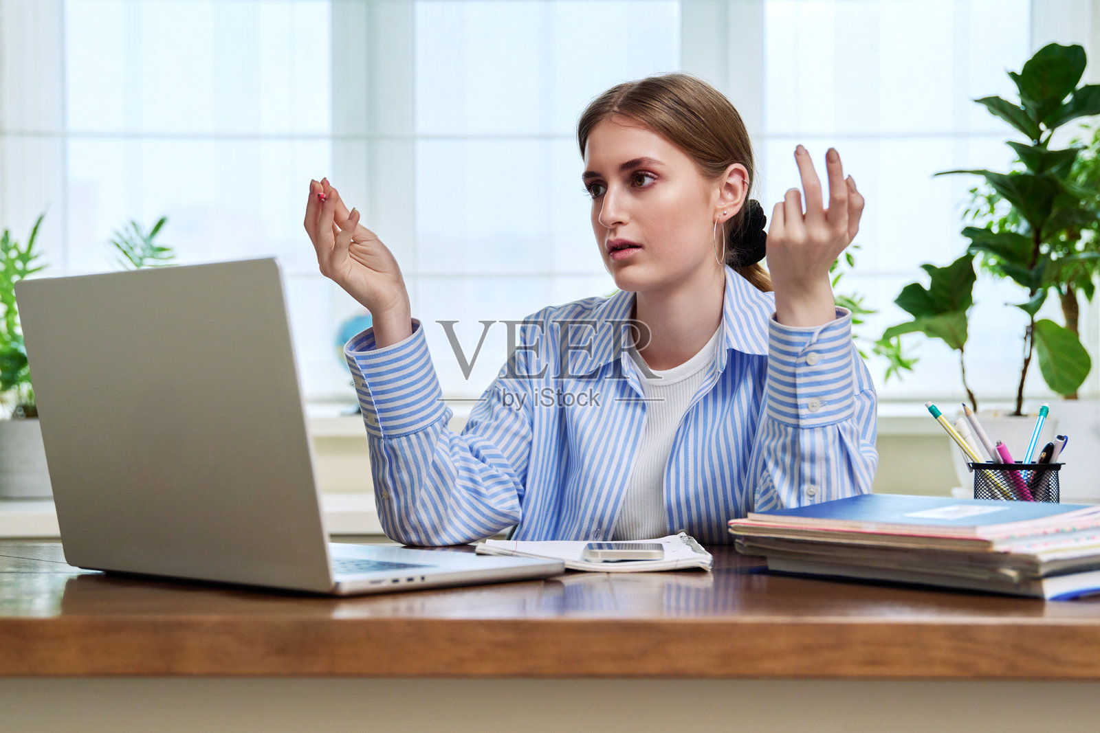 在家使用笔记本电脑参加视频会议的少女学生照片摄影图片