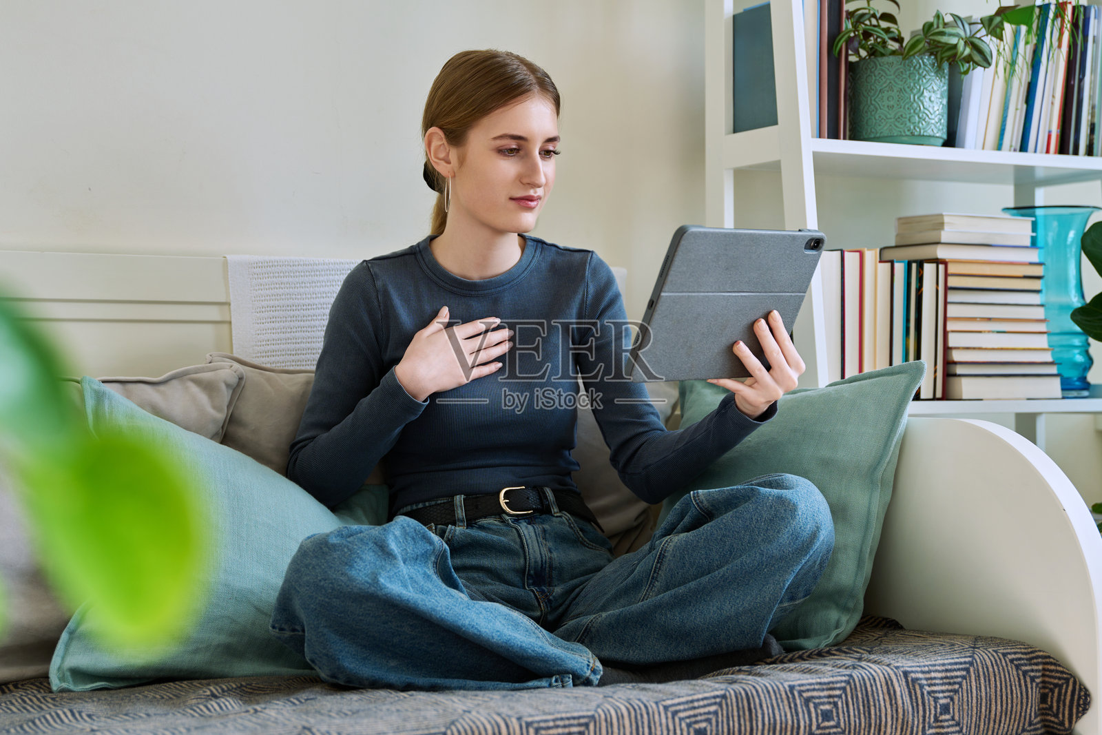 在家中用平板电脑网络摄像头交谈的青少年女学生照片摄影图片