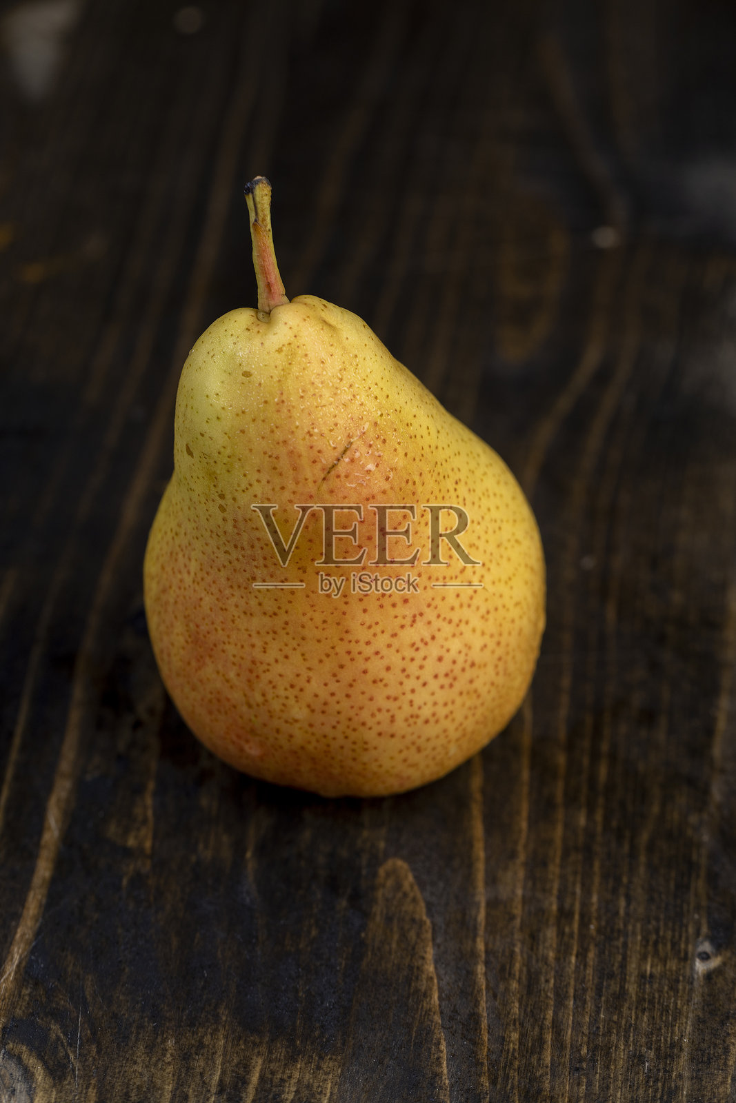 新鲜的红色梨子,带有黄色的色彩,放在桌子上照片摄影图片