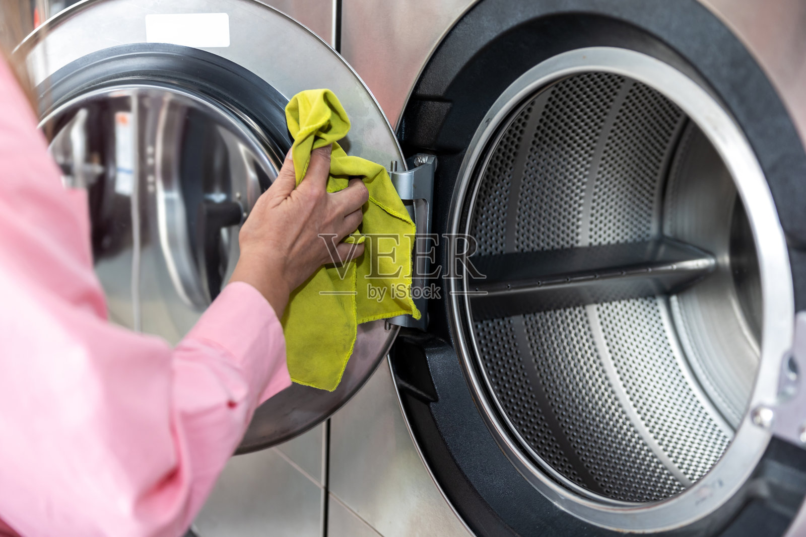 女性手部特写,正在清洁洗衣机的滚筒照片摄影图片