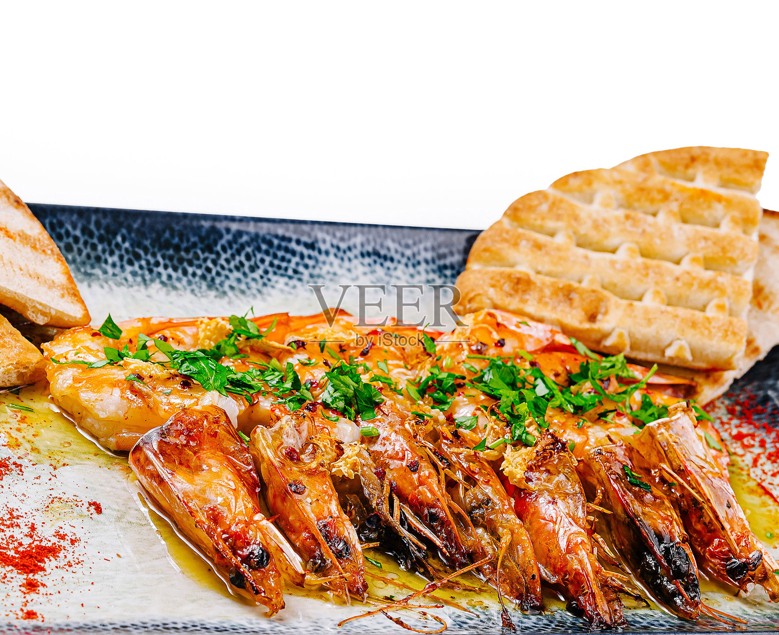 蒜香橄榄油虾配香菜和皮塔饼,摆放在长方形盘子上照片摄影图片