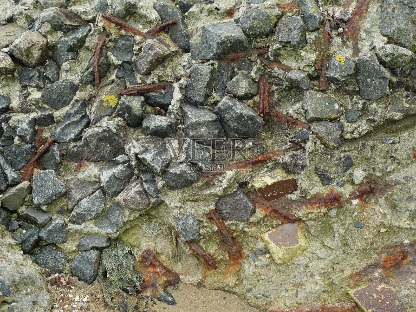 海滩上的混凝土碎片和生锈的铁块照片摄影图片