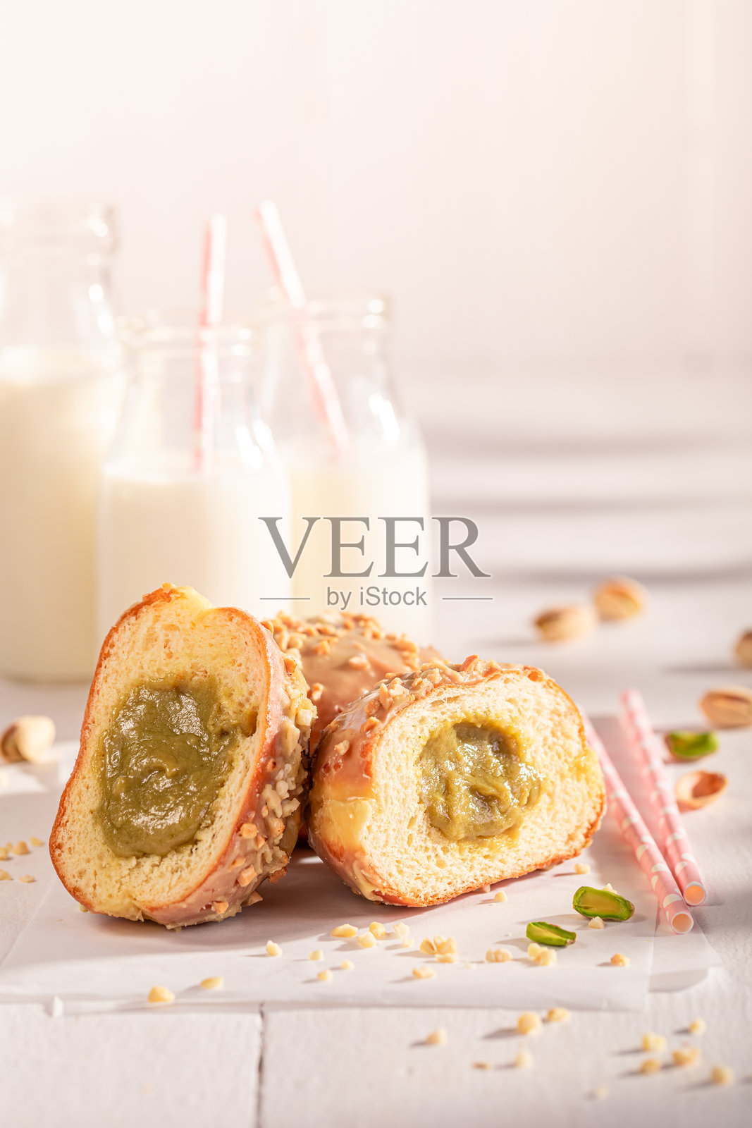 美味甜蜜的开心果甜甜圈,表面覆盖糖霜和坚果。照片摄影图片