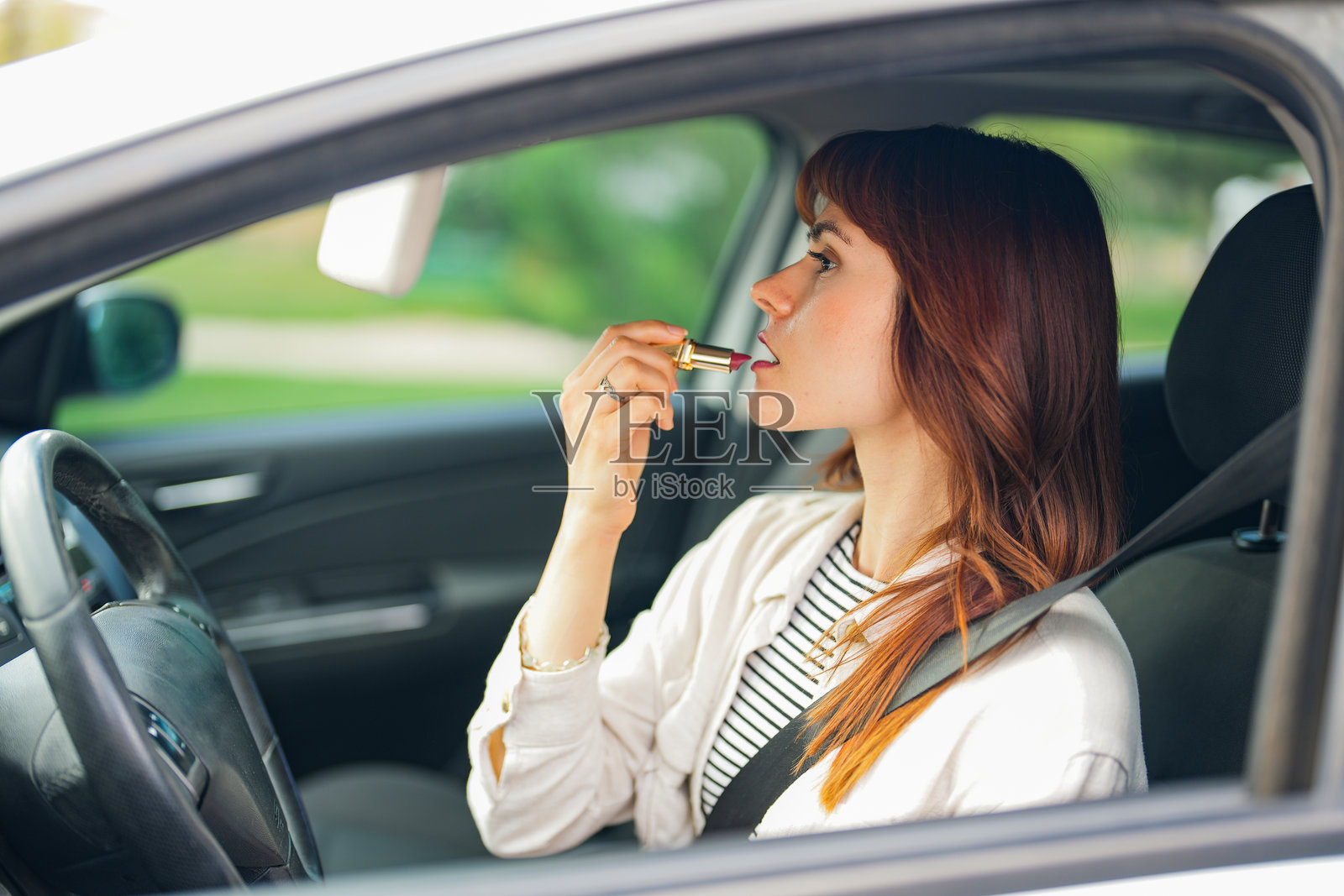年轻漂亮的女人在车座上化妆照片摄影图片