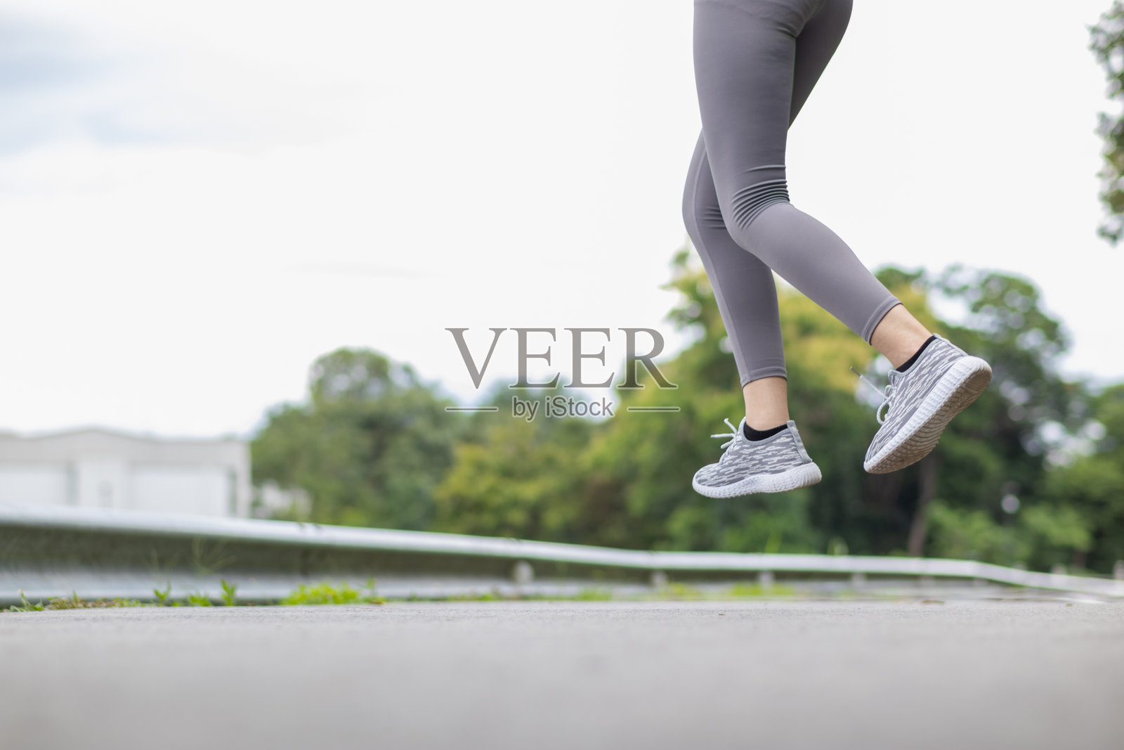 年轻的亚洲女性穿着运动胸罩和跑鞋,每天早晨去慢跑以保持健康,因为跑步可以帮助她的身体消耗多余的能量。健康跑步的概念。照片摄影图片