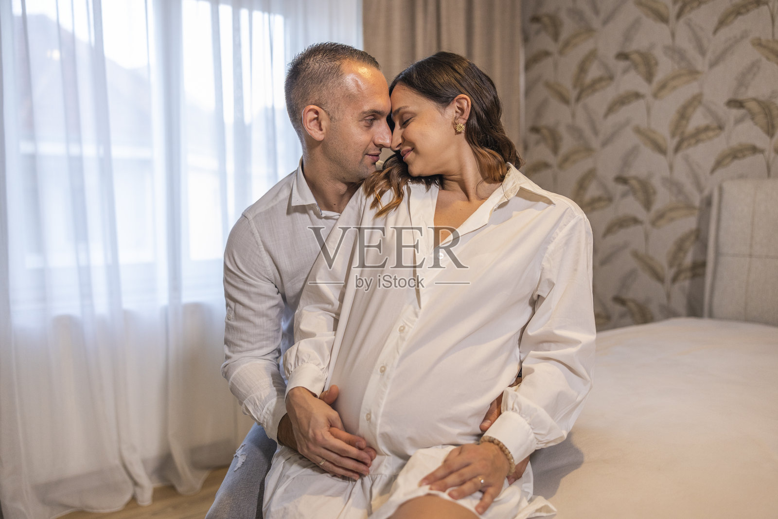 怀孕的情侣感受到爱意并关心怀孕的过程。照片摄影图片