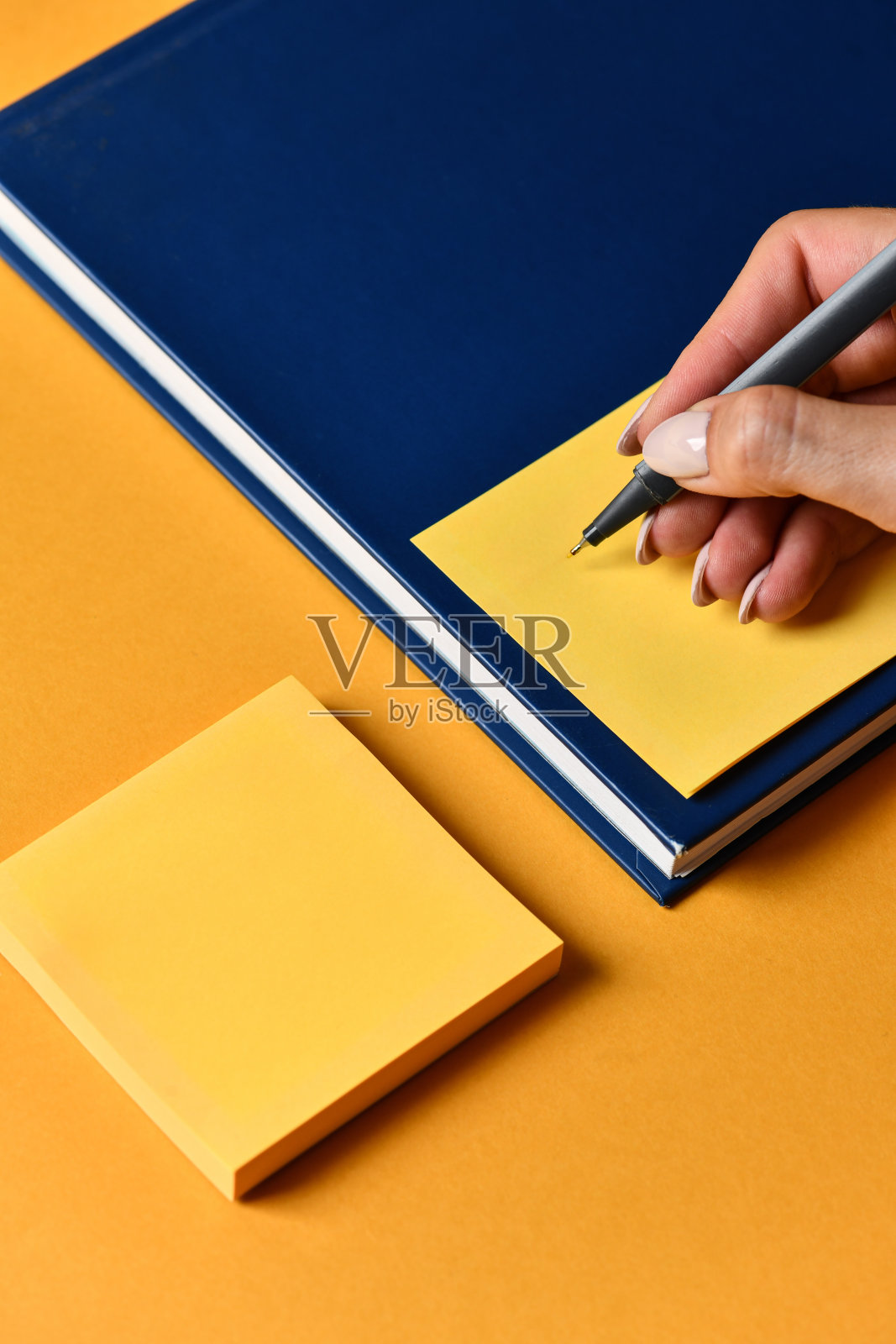 女性在橙色便签纸上写字照片摄影图片