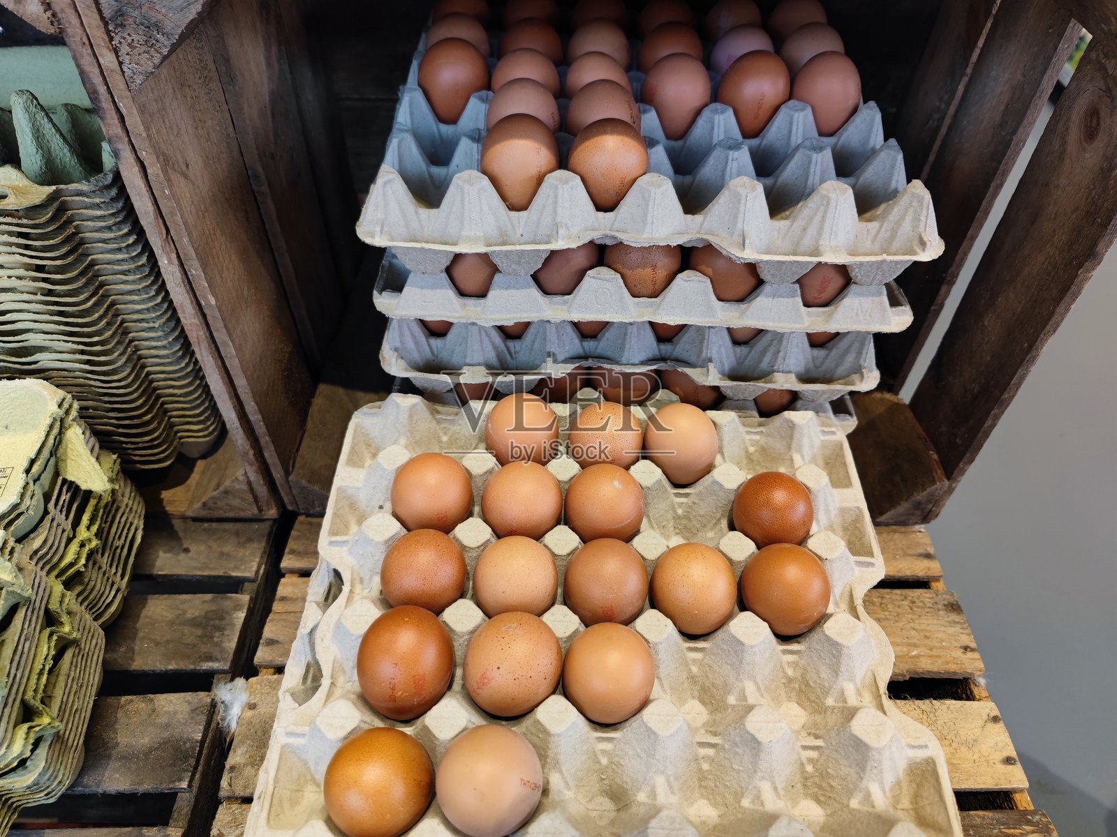 叠放的纸板蛋托箱内装有新鲜鸡蛋,摆放在超市货架上待售。照片摄影图片