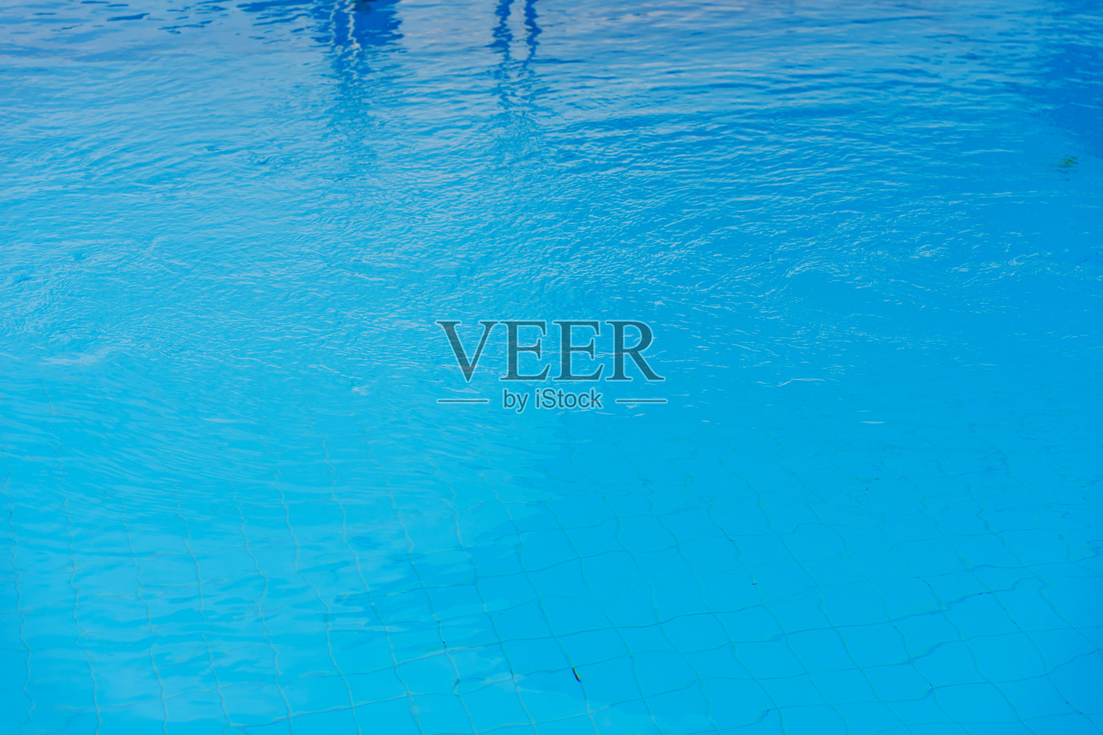 泳池中蓝色水面上的涟漪。游泳池的水质净化。照片摄影图片