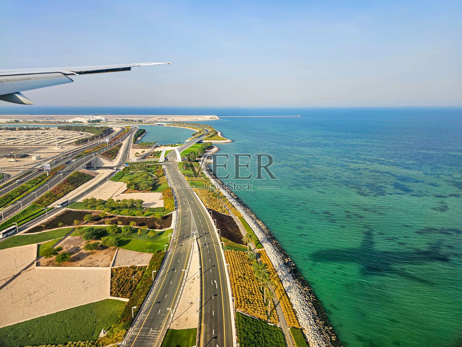 海岸公路和海洋的鸟瞰图,飞机的影子映在水面上。照片摄影图片