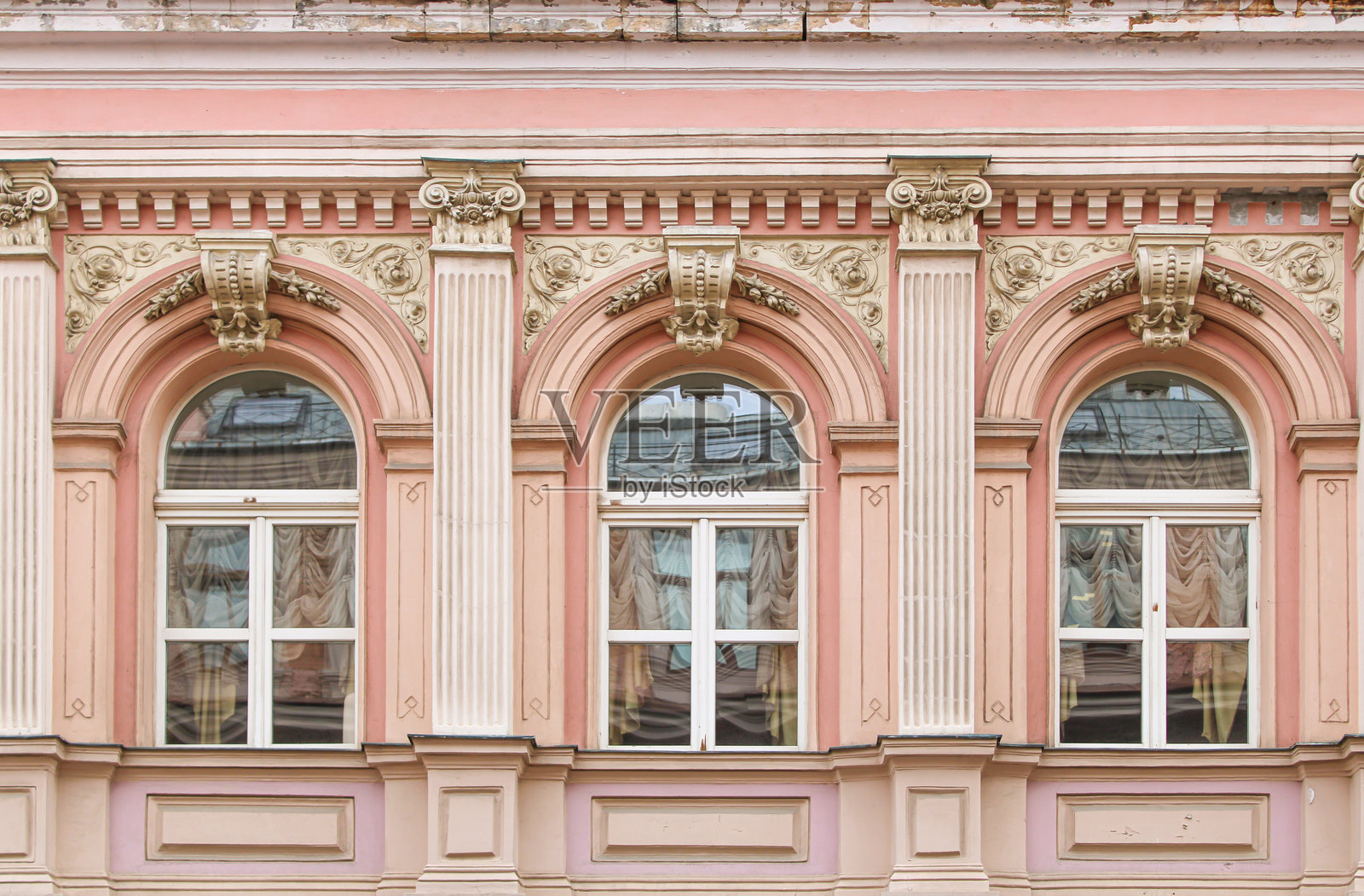 白色建筑侧面有三个不同的窗户。照片摄影图片