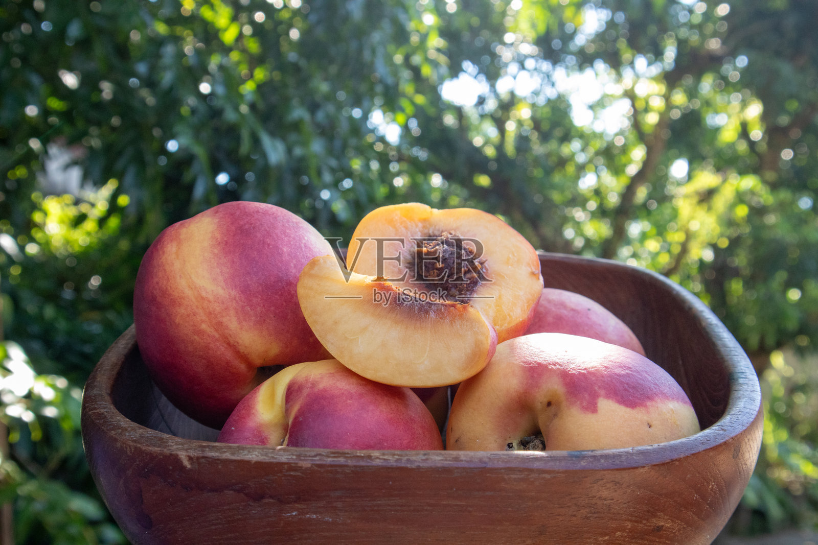 新鲜的桃子来自果园,整齐地放在一个木篮里。桃子是一种甜美而酸爽的水果,富含抗氧化剂,有助于滋养肌肤,使其更加光滑、柔软和水润。照片摄影图片